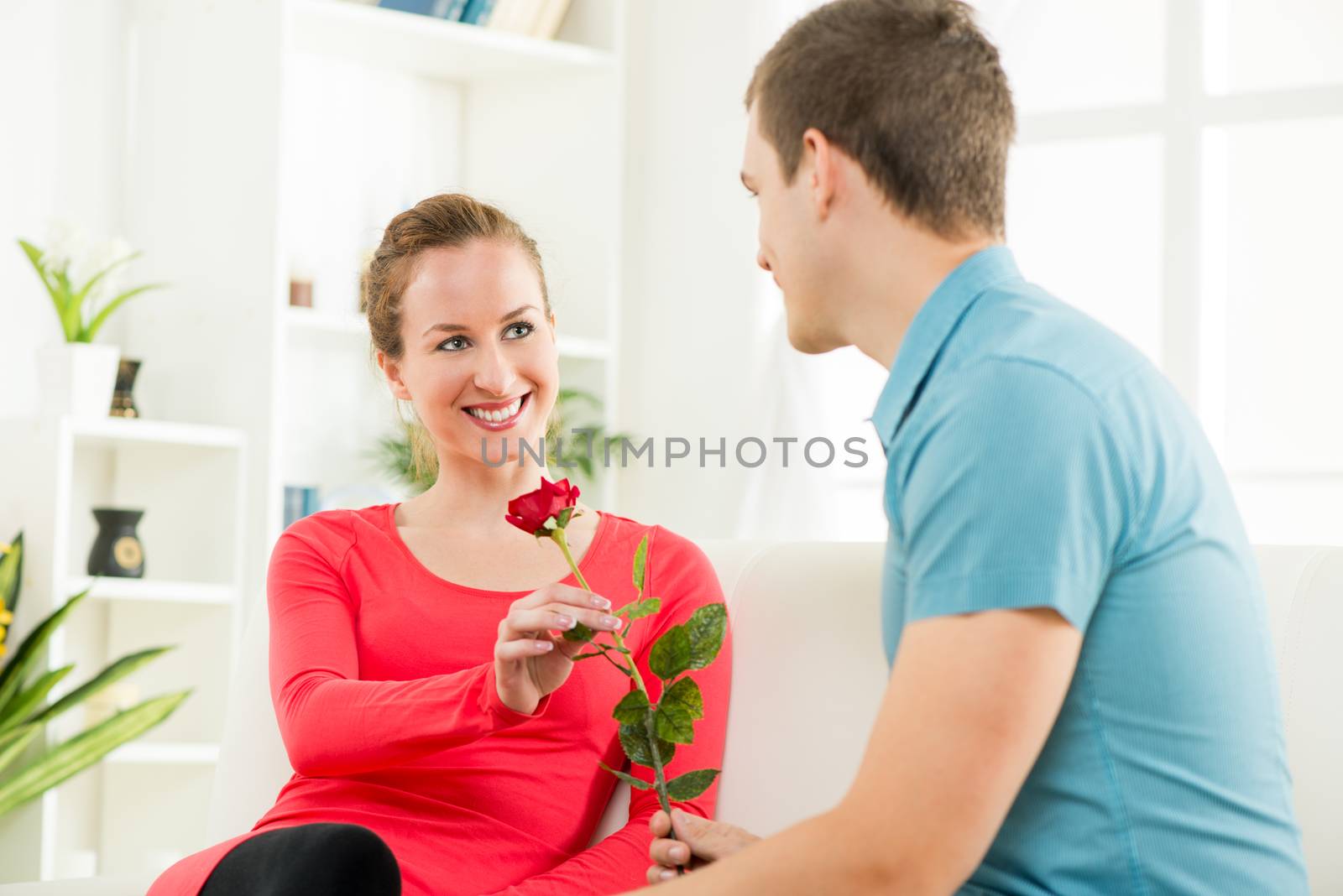 Young boyfriend giving rose his beautiful girlfriend
