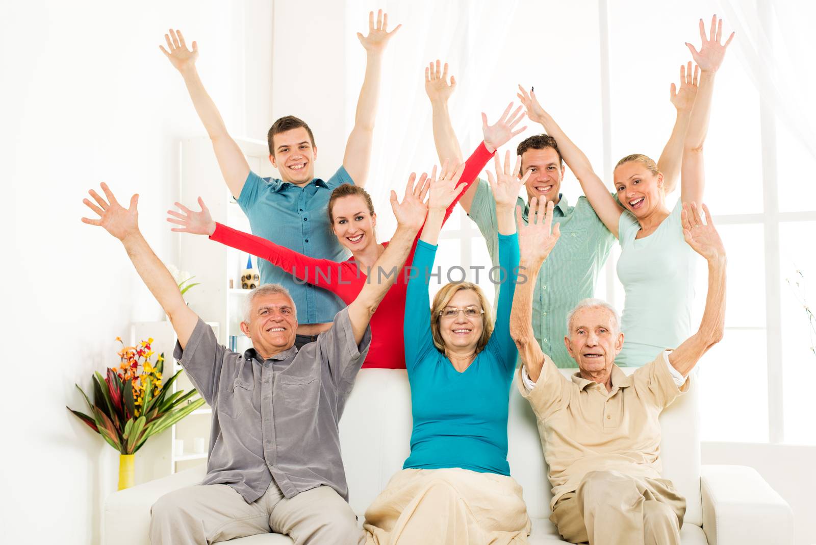 Big cheerful family enjoying at home and rejoices with open arms 