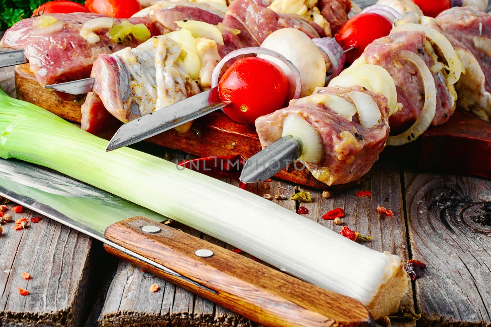raw meat with vegetables threaded onto a skewer for roasting on the coals