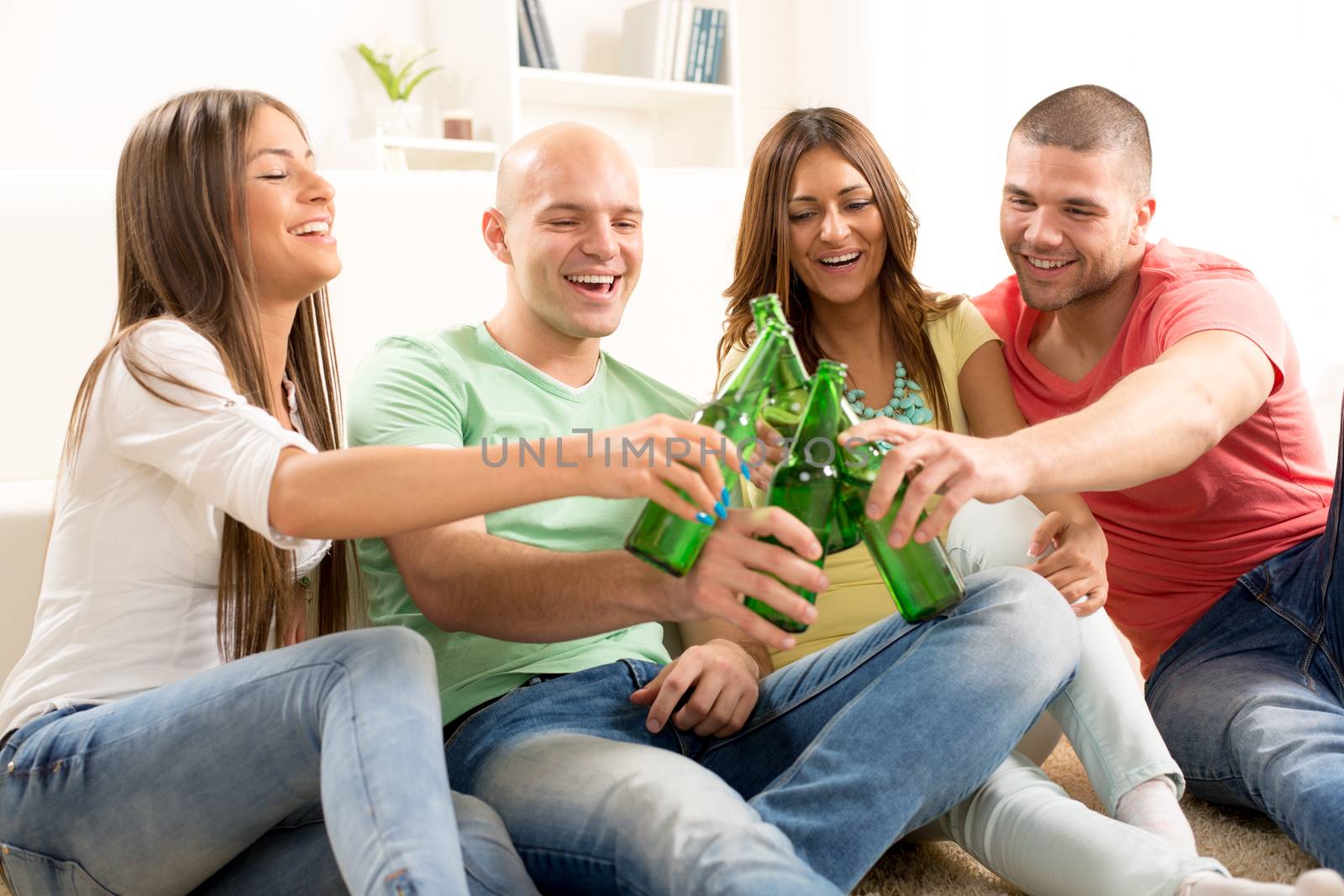 Friends enjoying with beer and cheers together at home party.