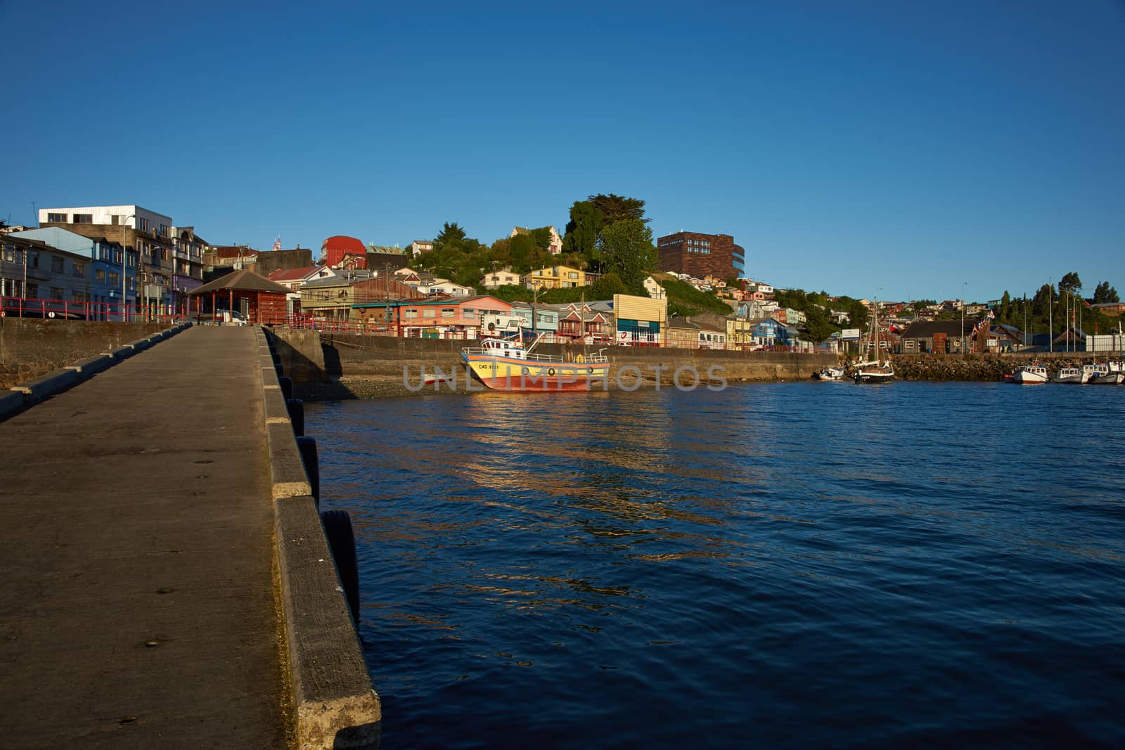 Colourful fishing boat resting on the shore in Castro, capital of the Island of Chiloe in Chile.