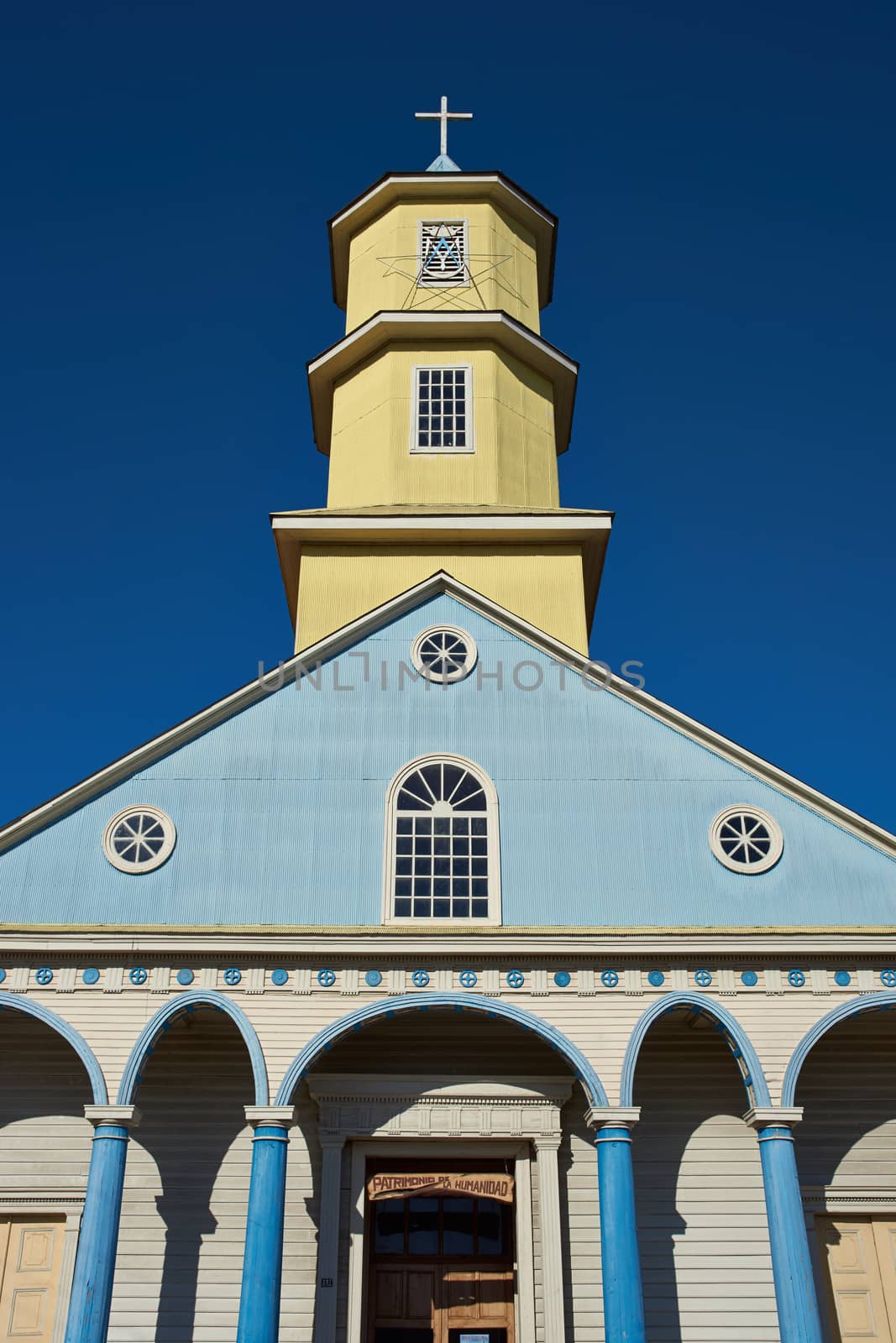 Yellow and blue facade of the historic 19th century wooden church in Conchi on the island of Chiloé in southern Chile.