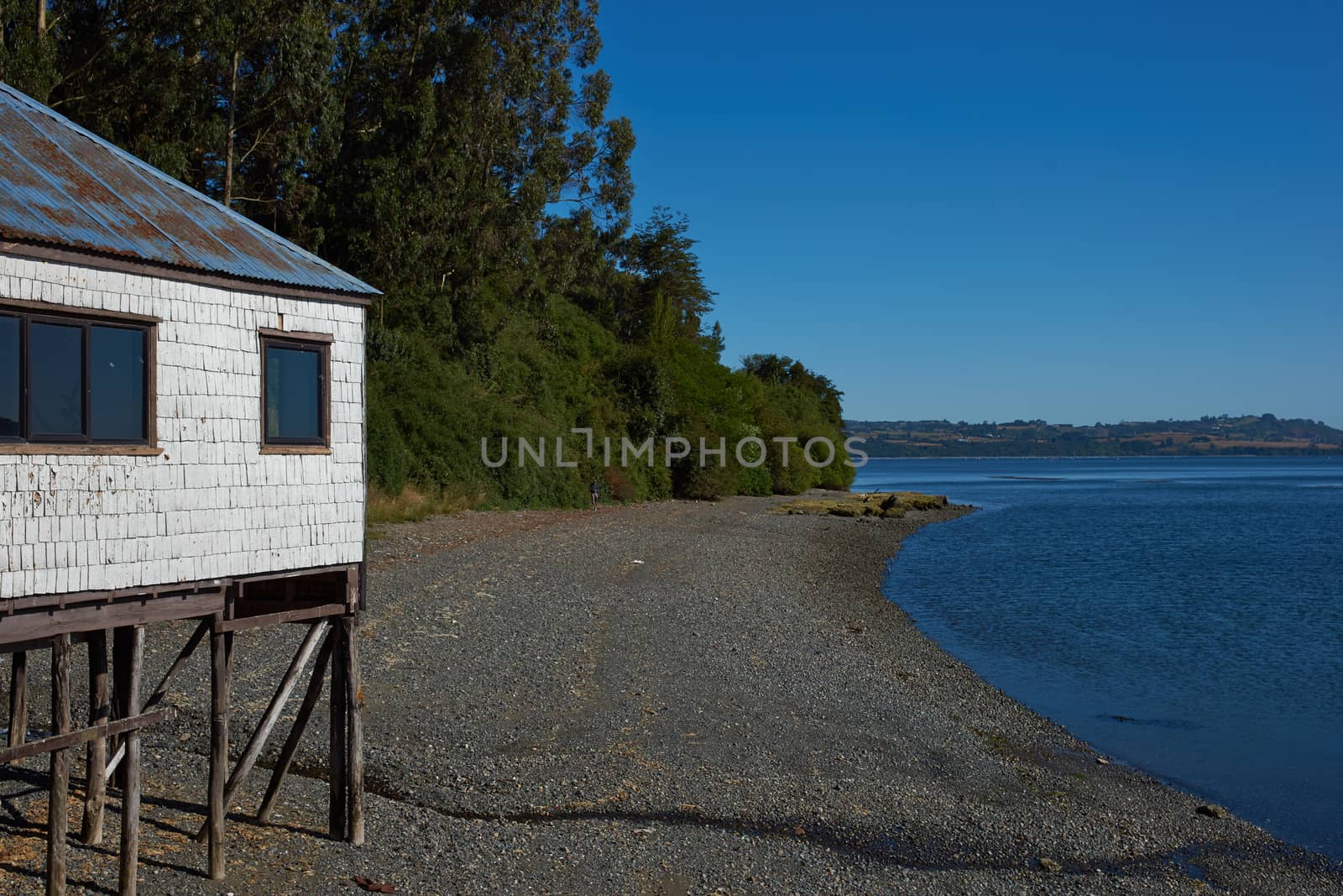 Wooden building standing on stilts on the sea shore at Conchi, a small coastal town on the Island of Chiloe in Chile.
