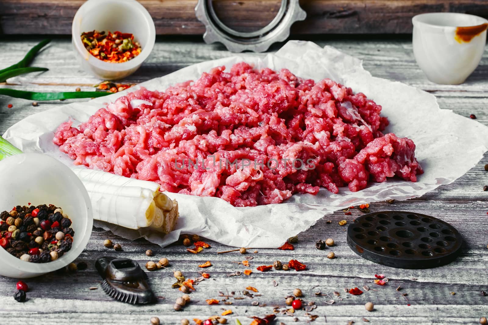 Fresh ground beef with spices on paper for baking