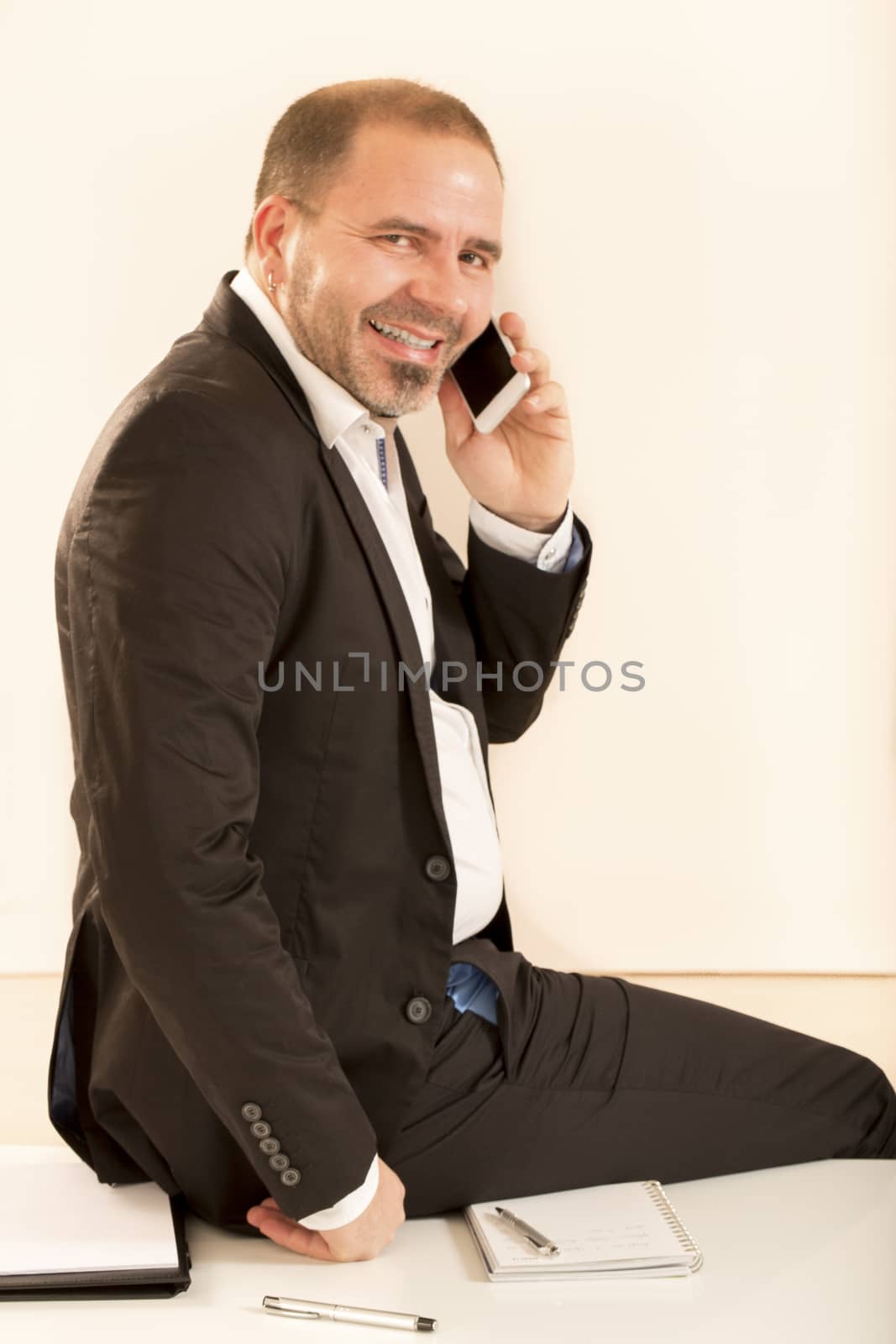 Attractive man talking on the telephone with his business partner. At the office, white background