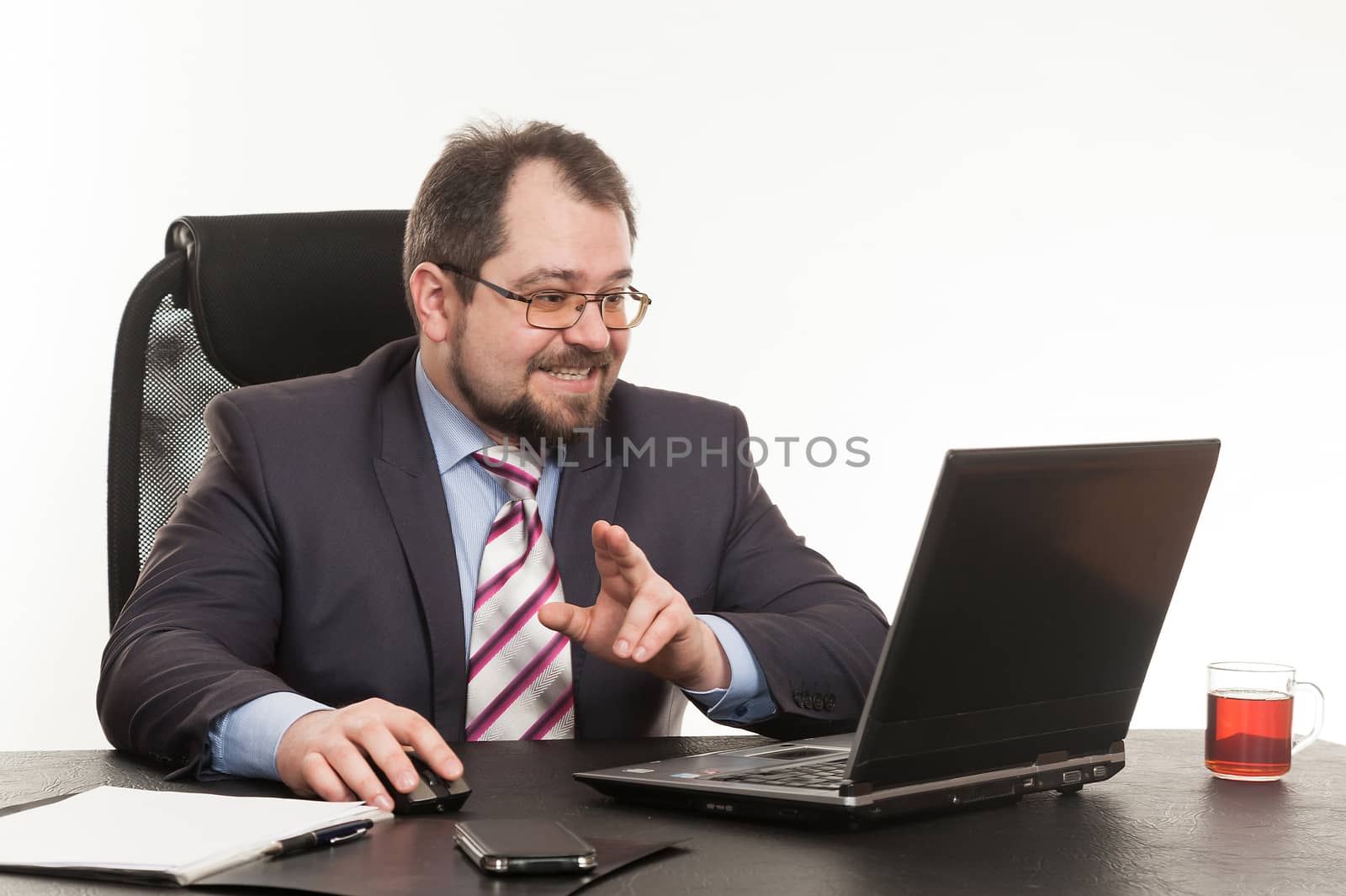 the businessman sits at office table with the laptop