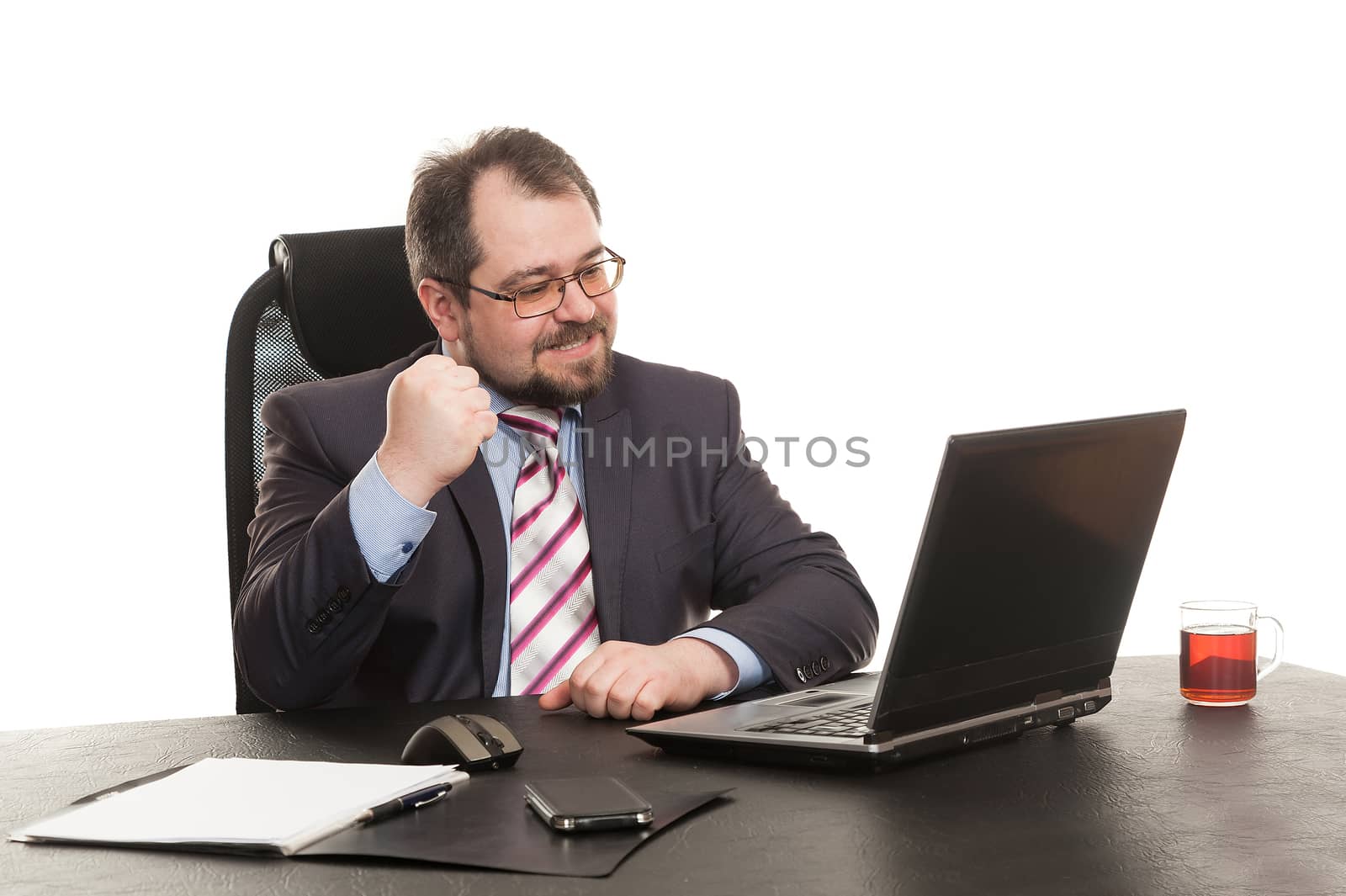 the businessman sits at office table with the laptop