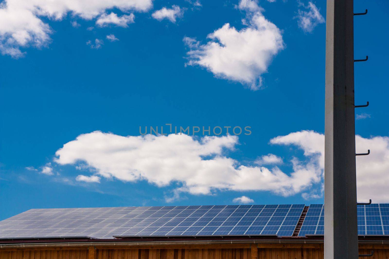 Building with solar panels and sky with white clouds