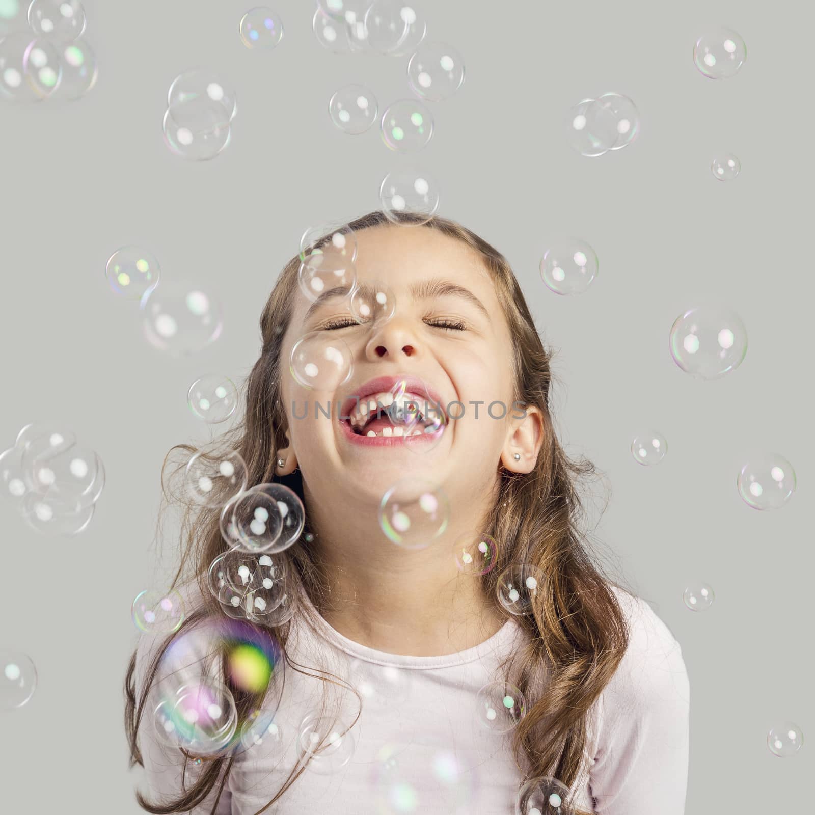 Girl playing with soap bubbles by Iko