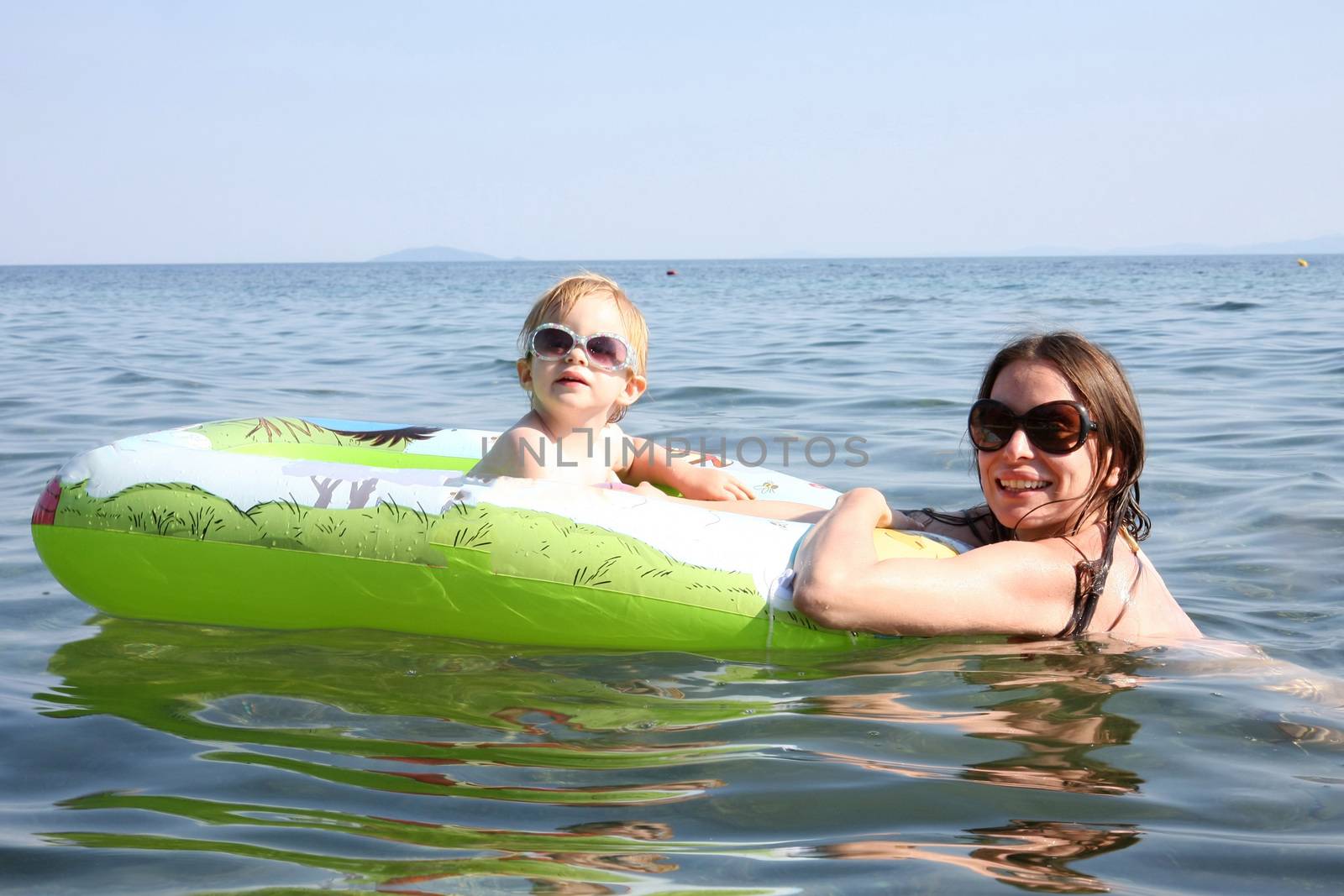 Mother and daughter floating in the sea by tdjoric