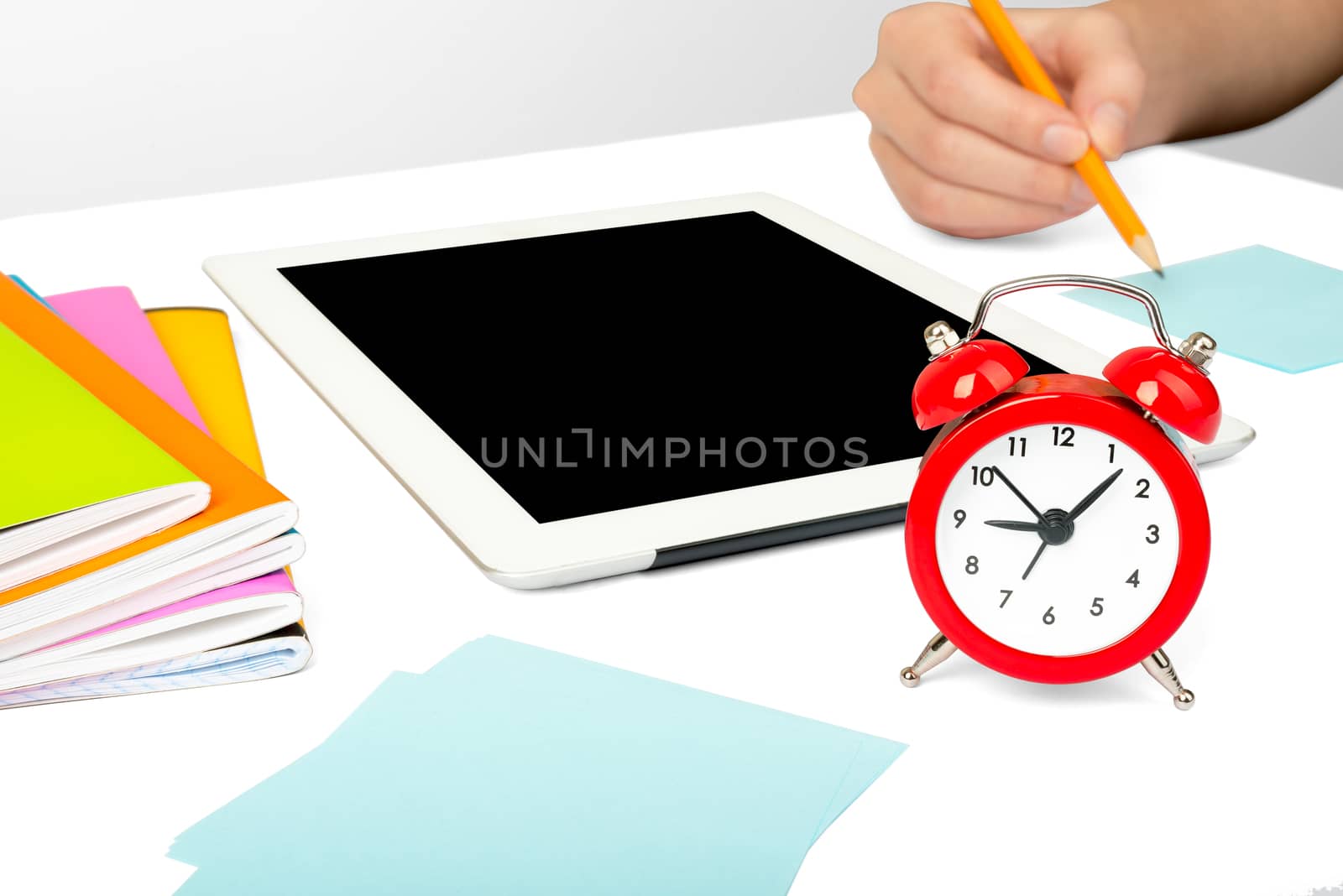 Females hand using tablet isolated on white background with alarm clock