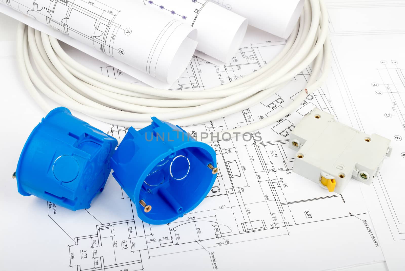 Architecture plan and rolls of blueprints with cabel and blue plastic covers, closeup. Building concept