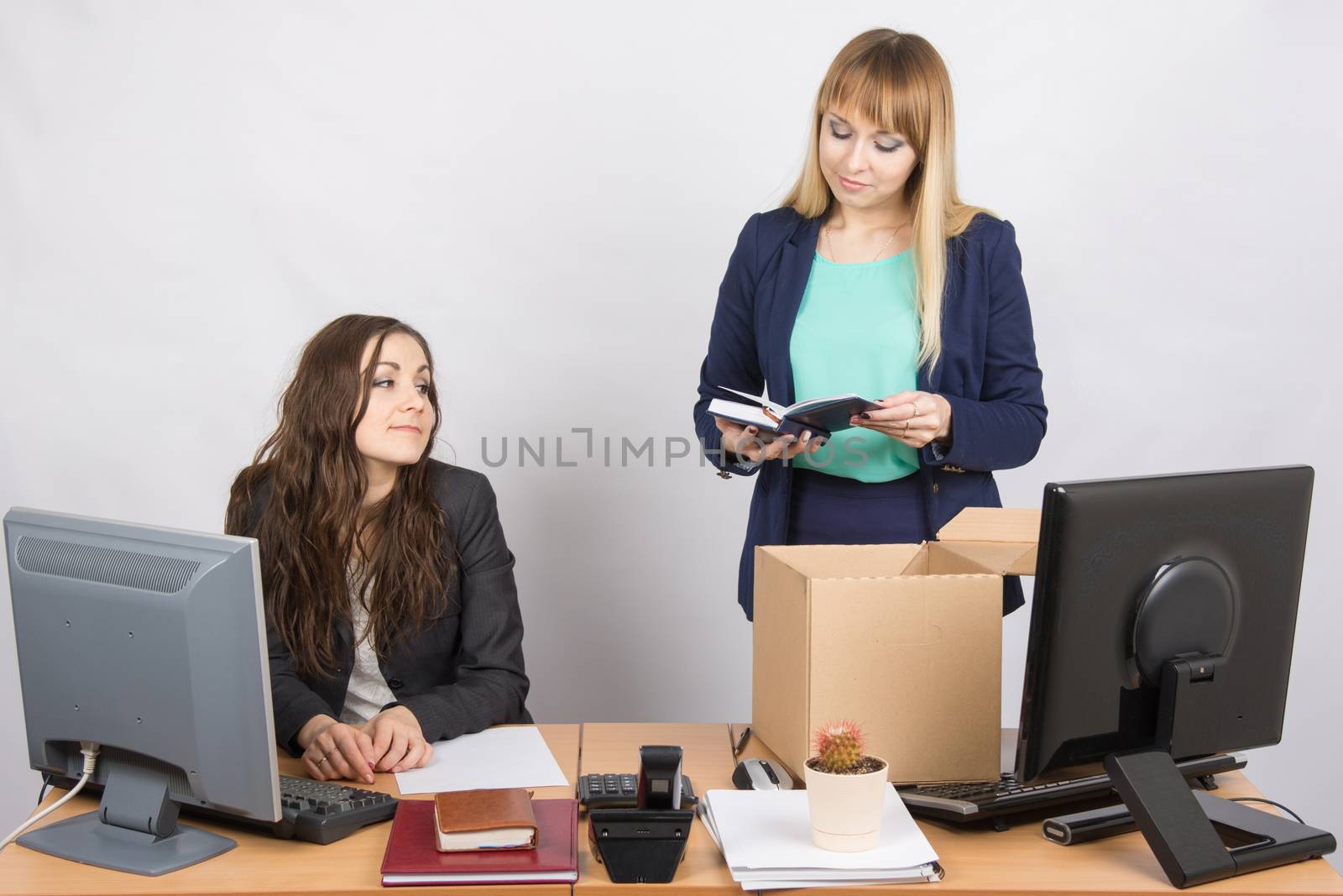 An employee in the office happily arranges things around, watching her colleagues