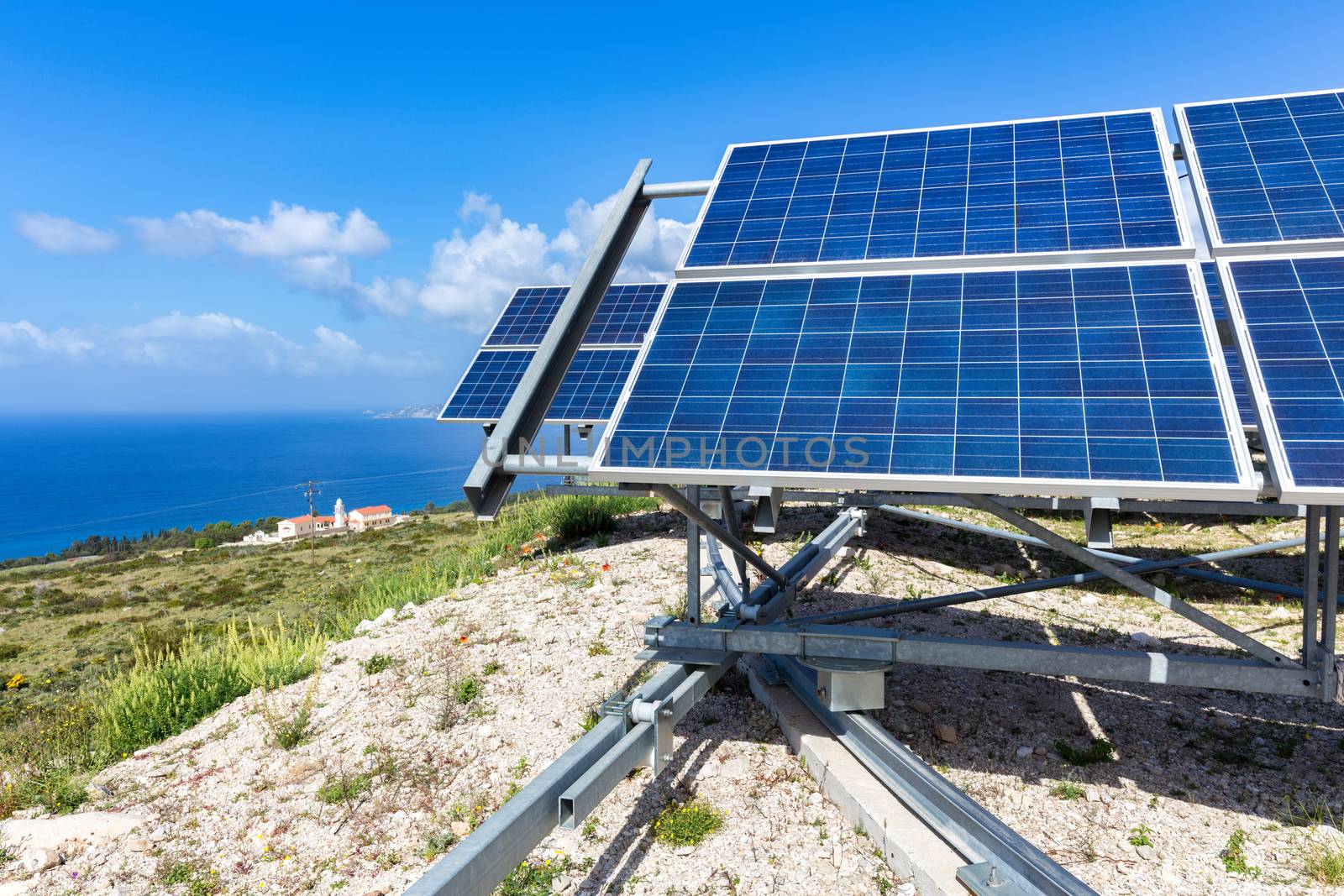 Blue solar panels at coast near sea in Kefalonia Greece by BenSchonewille