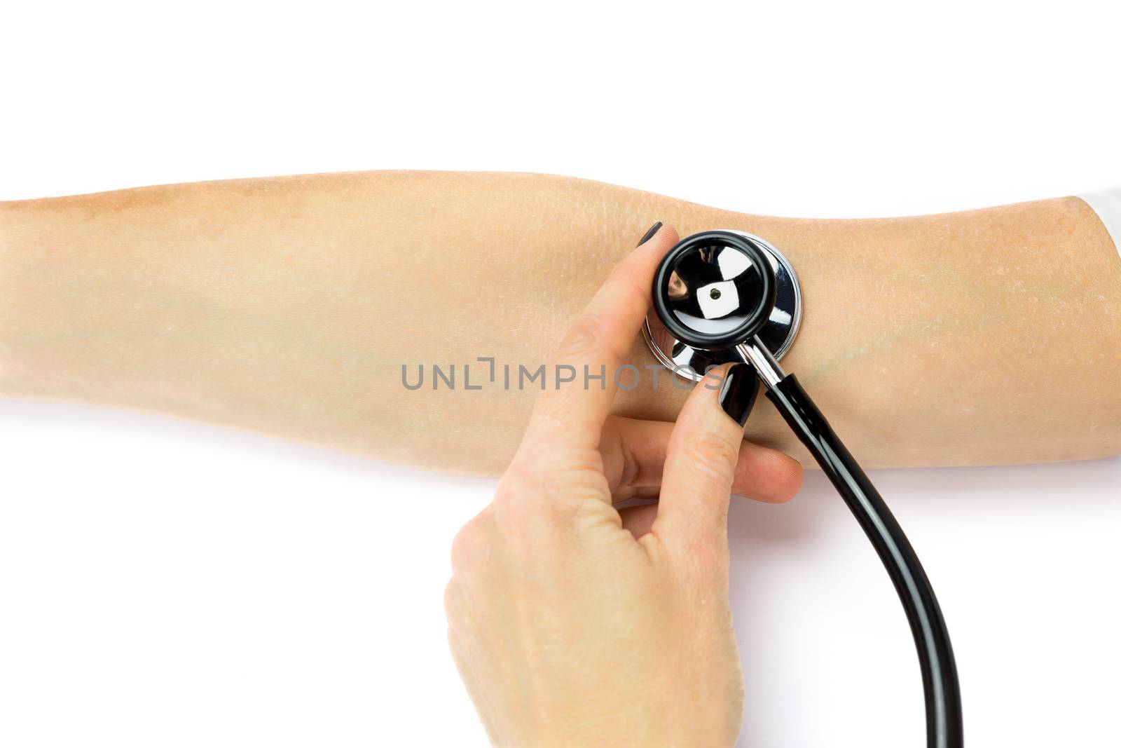 Female hand holding stethoscope on arm of patient by BenSchonewille