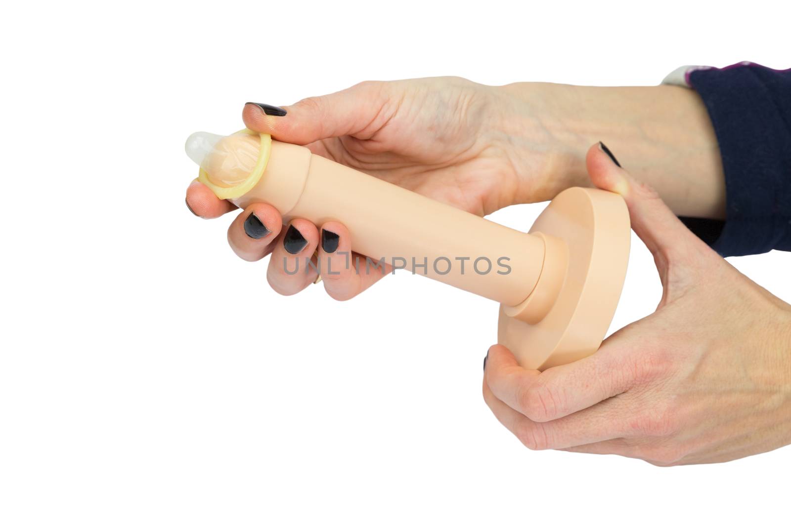 Hands of woman showing condom use on plastic penis model isolated on white background