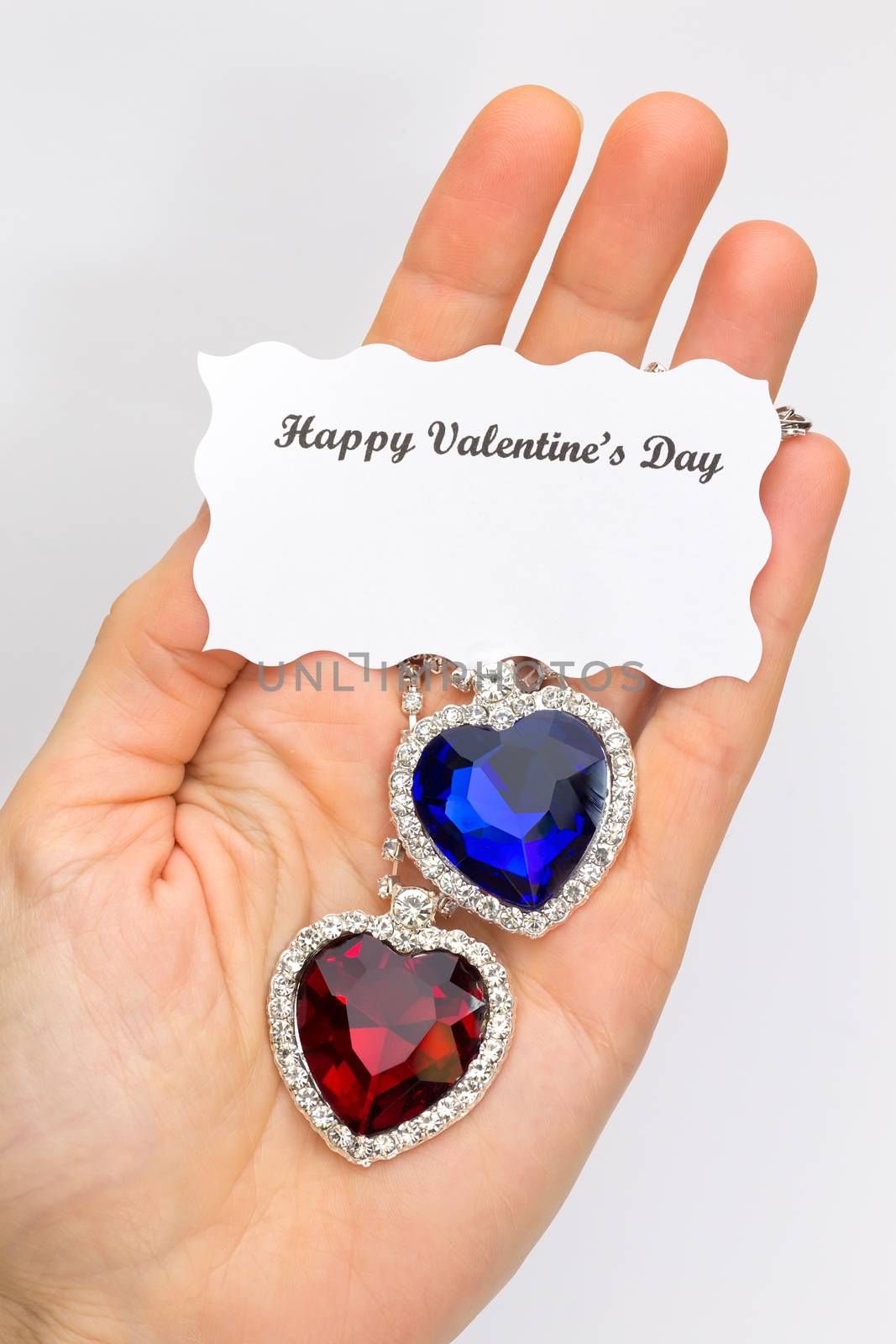 Hand showing red and blue jewelry hearts for valentine  by BenSchonewille