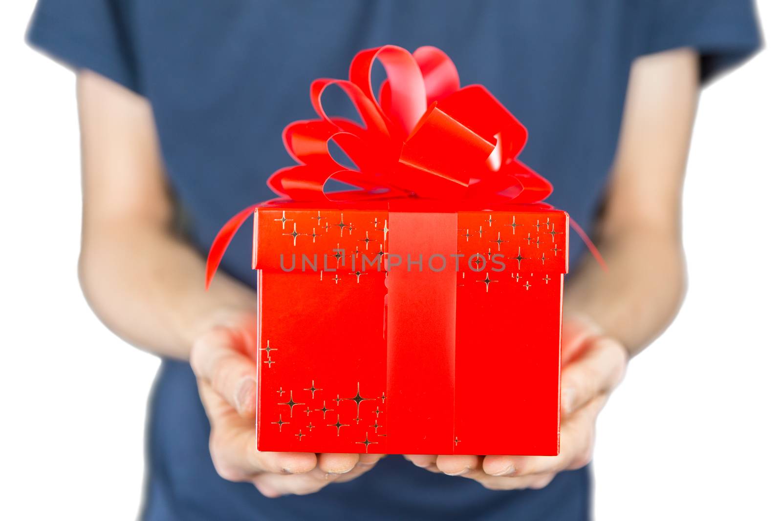 Young man holding red christmas present with stars in front of body