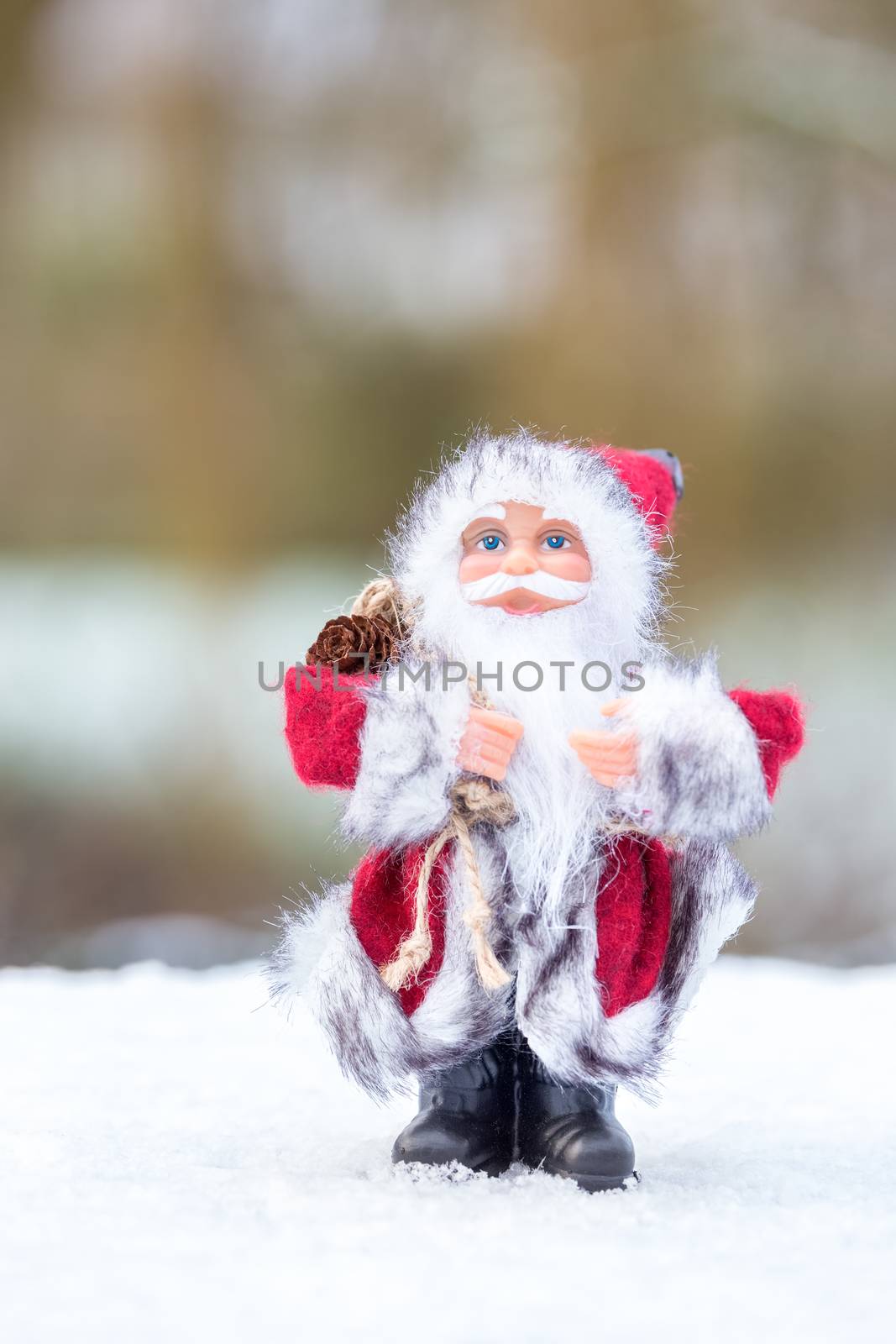 Santa Claus figurine standing in white snow outside