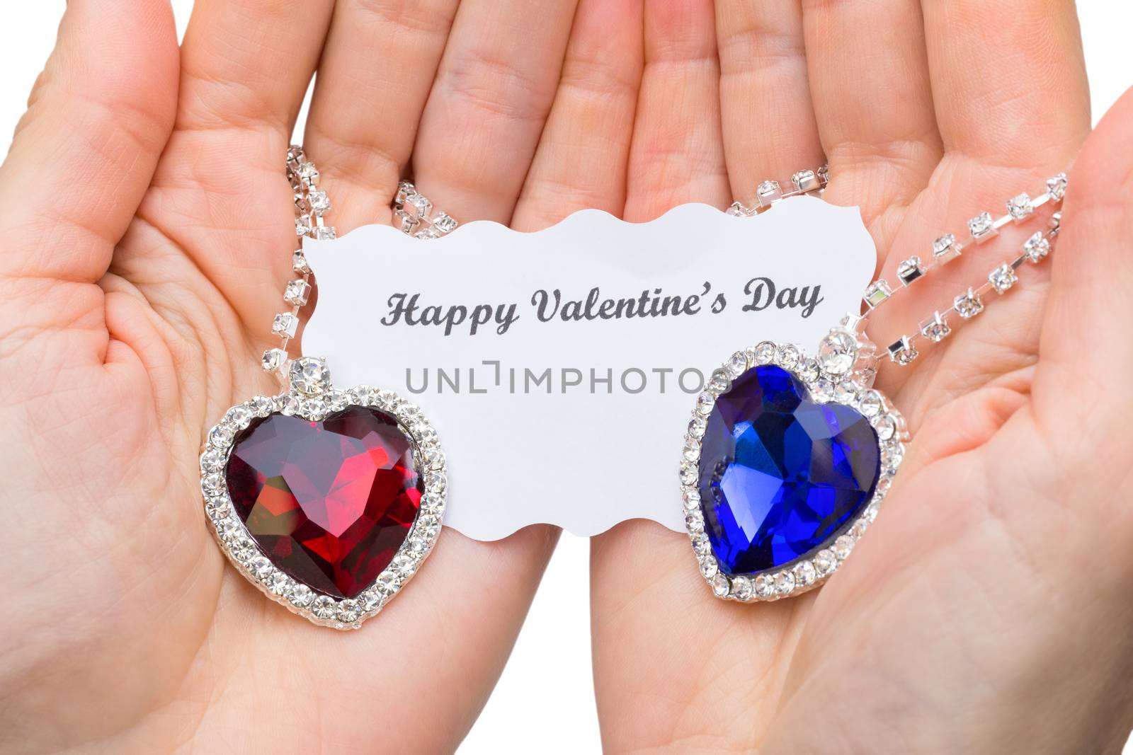 Red and blue jewelry heart with valentine card on hands by BenSchonewille
