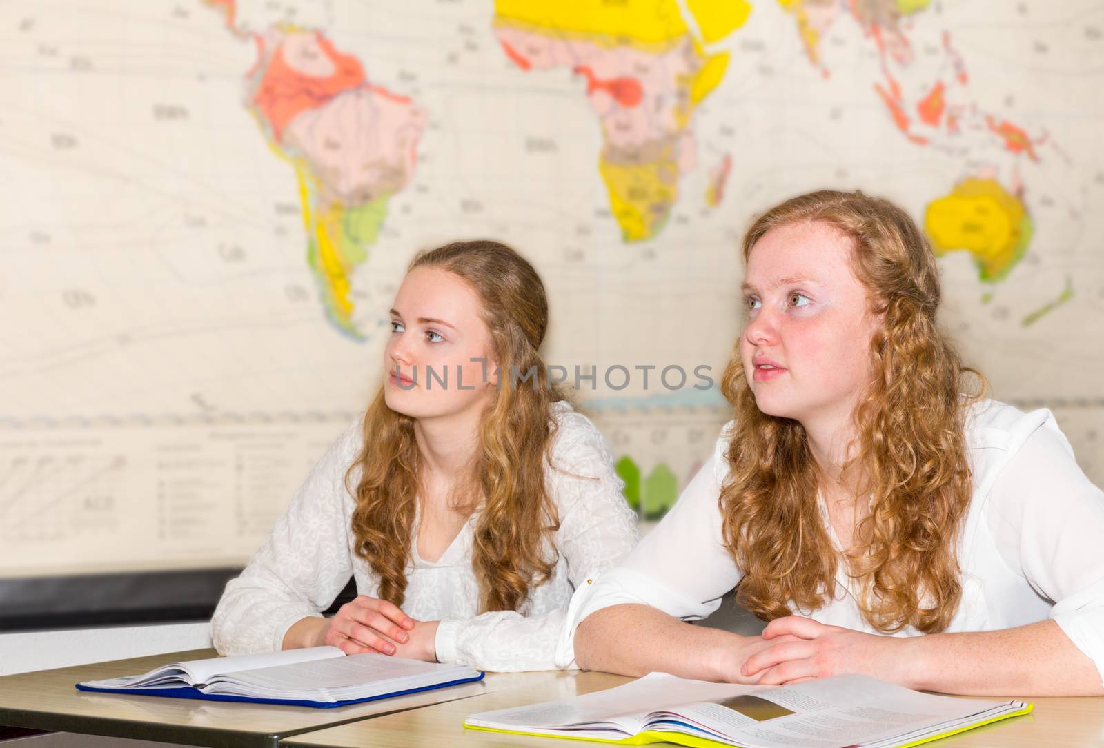 Two girl  students in geography class with  world chart