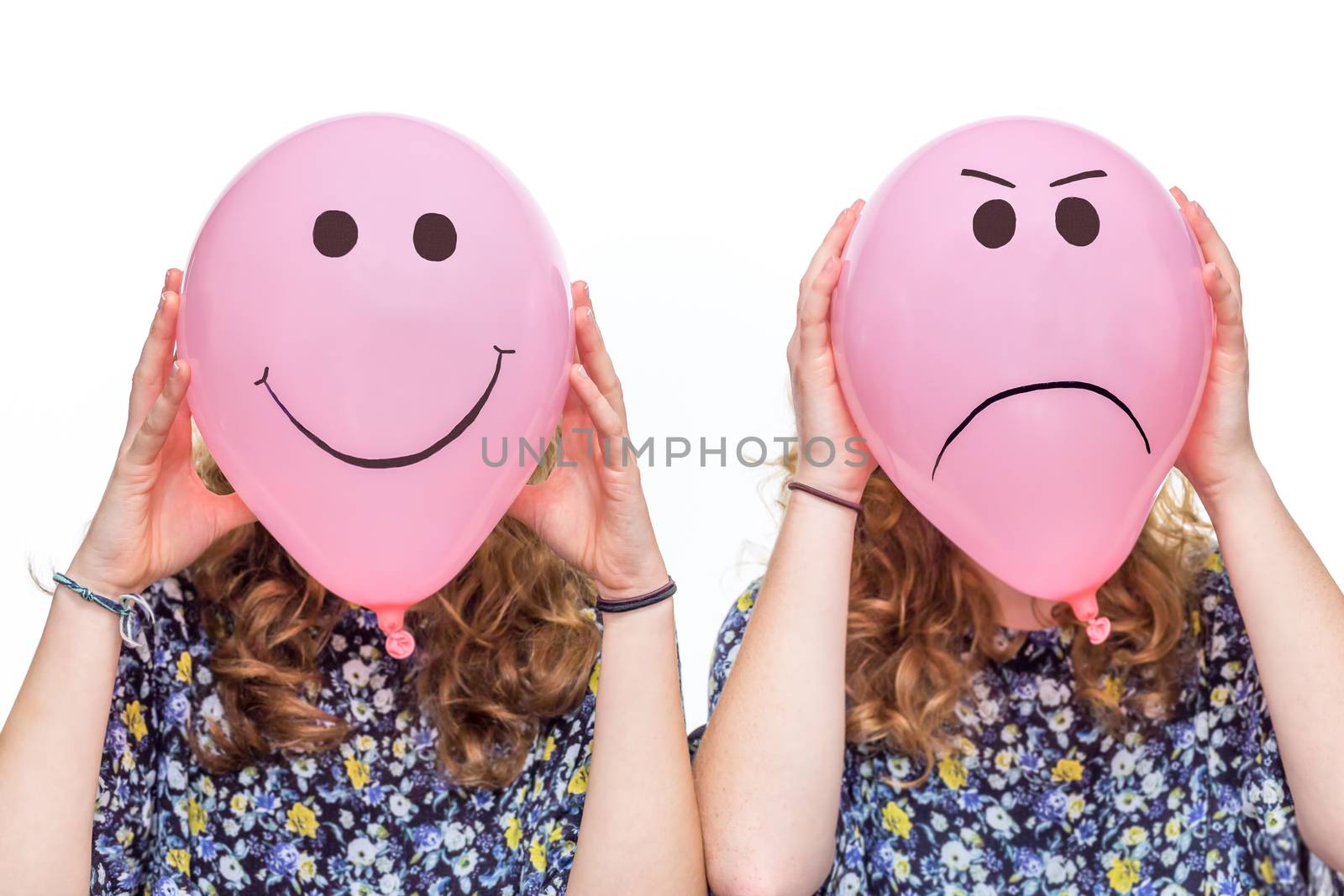 Two women holding pink balloons with happy and angry facial expressions for their heads isolated on white background