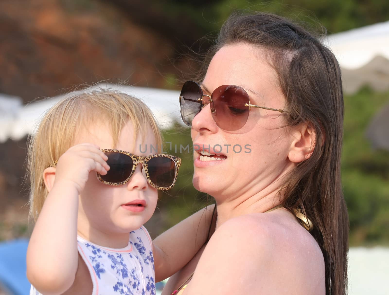 Portrait of mother and her baby girl posing with glasses