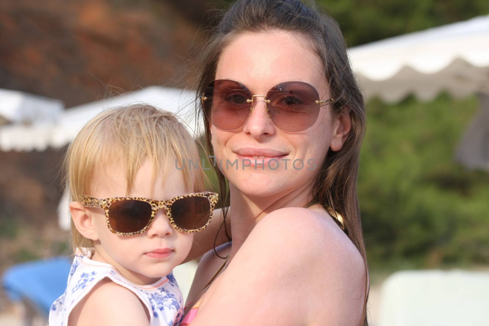 Portrait of mother and her baby girl posing with glasses