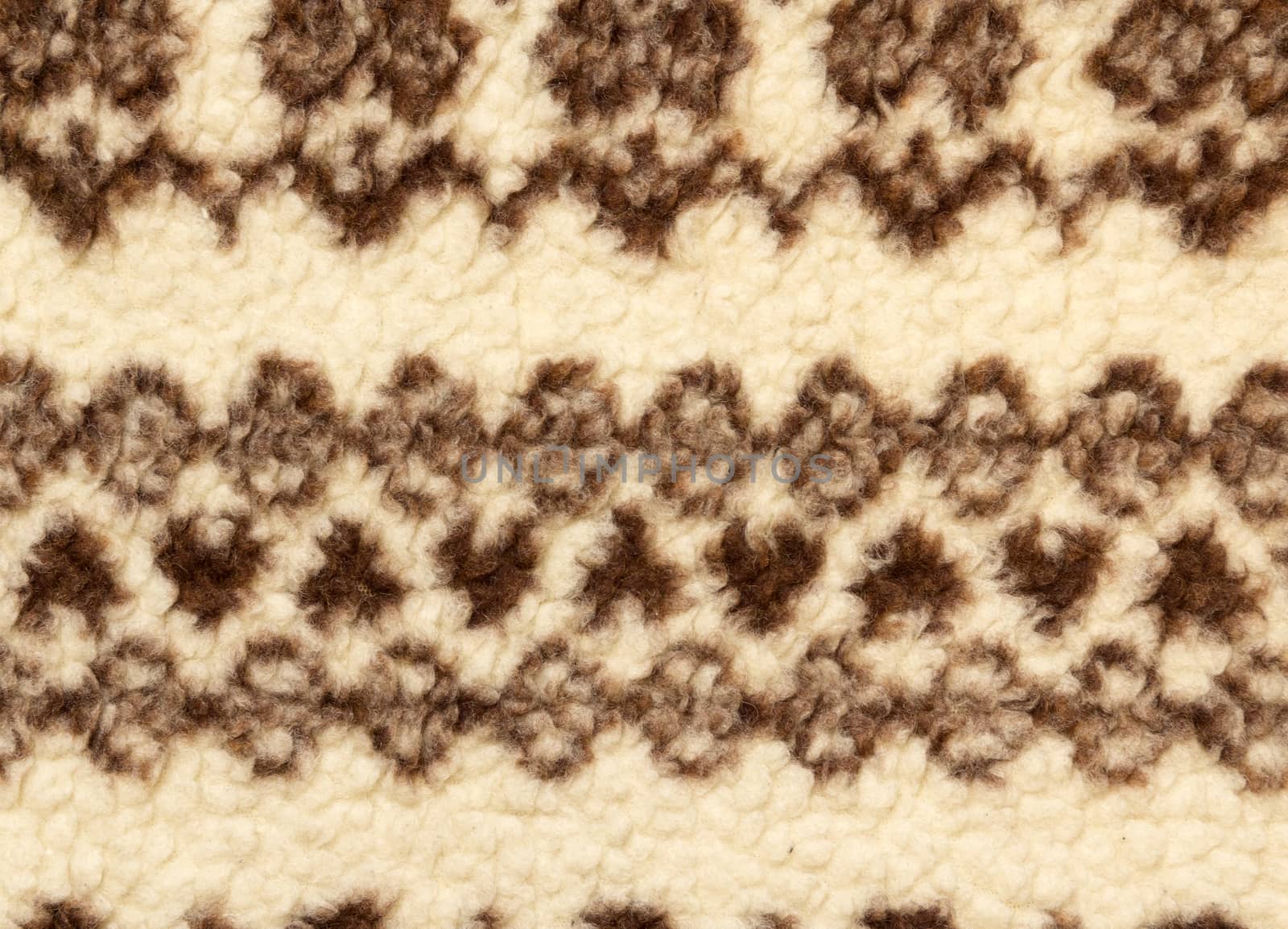 Close-up of knit fabric background with knitted grey and white geometric pattern
