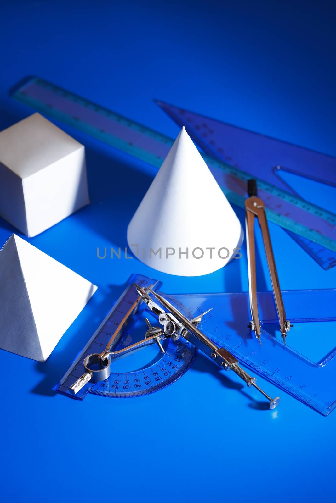 Geometry concept. Set of various paper shapes near rulers and divider