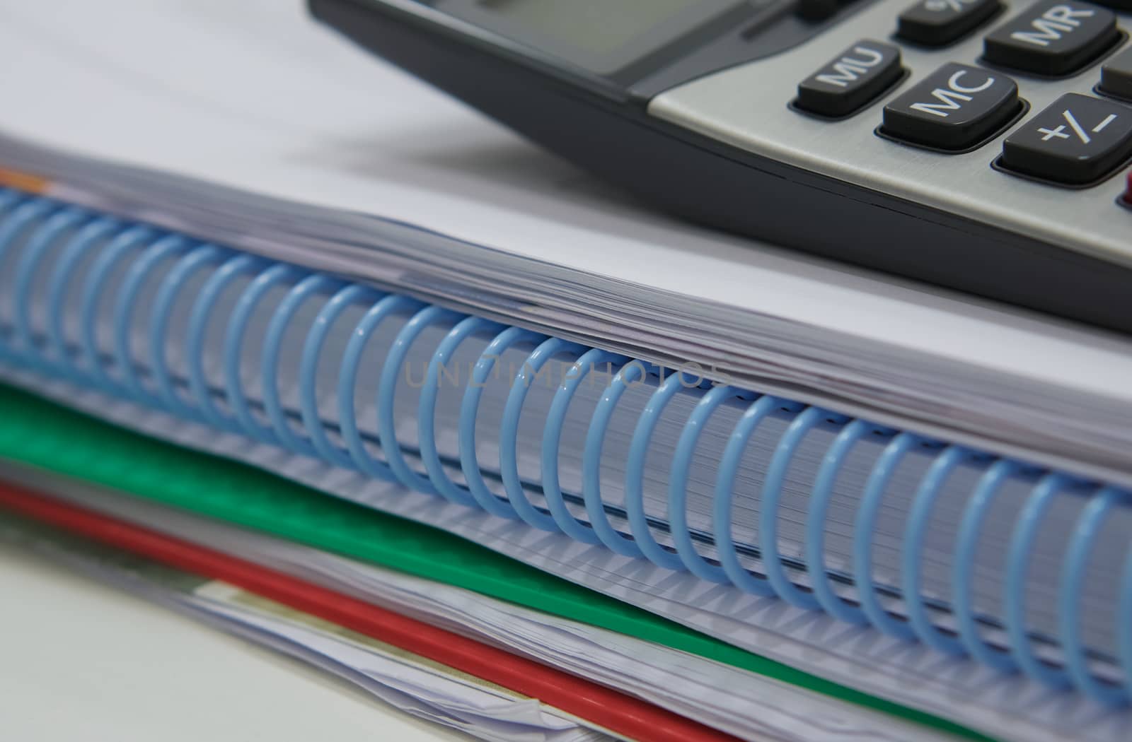 Stack of paperwork and calculator by ninun