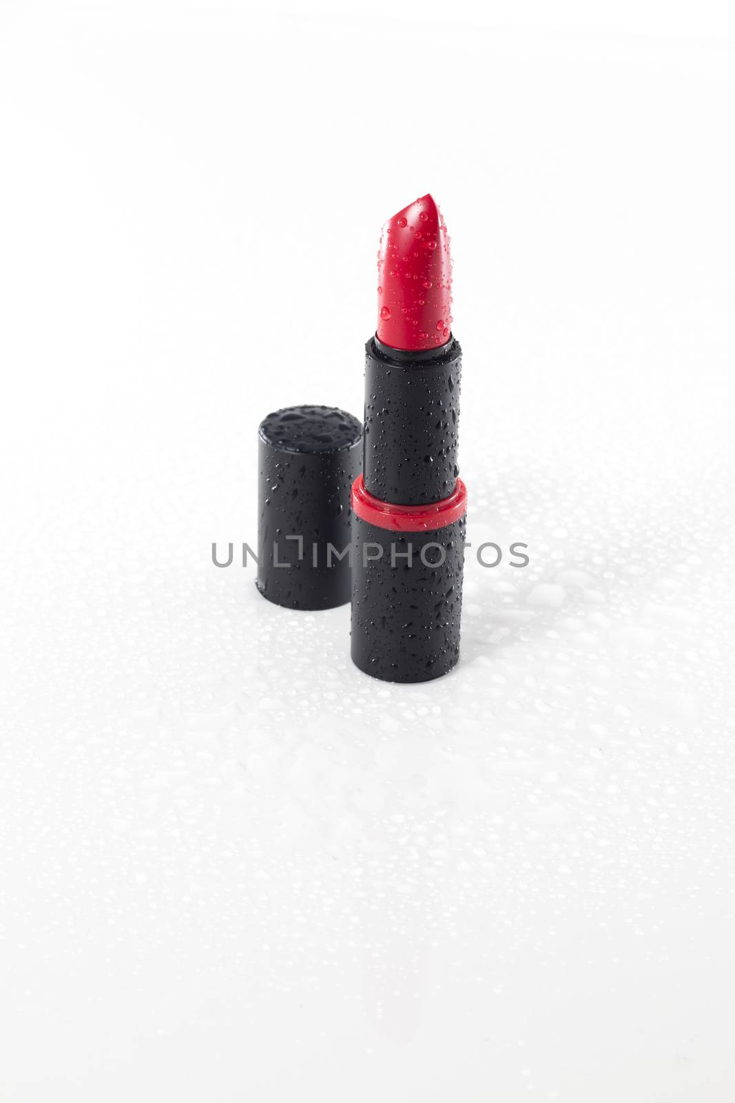 red lipstick with water drops isolated on white background by avanheertum