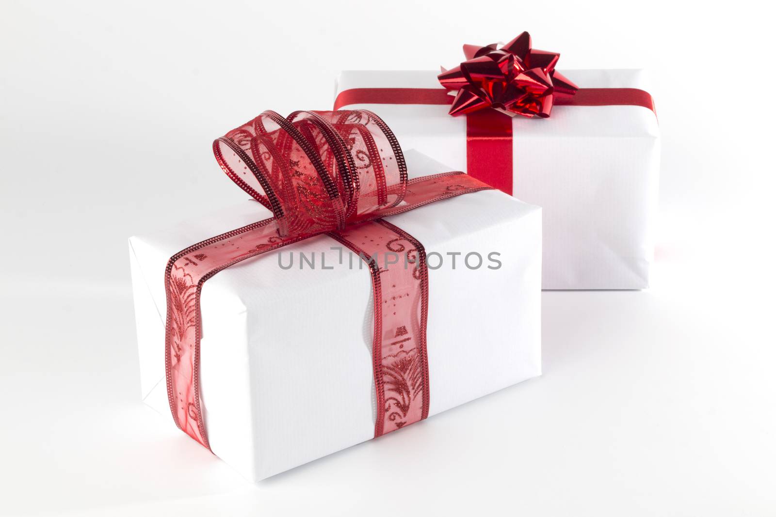 White presents with red ribbons and bows, isolated on white background