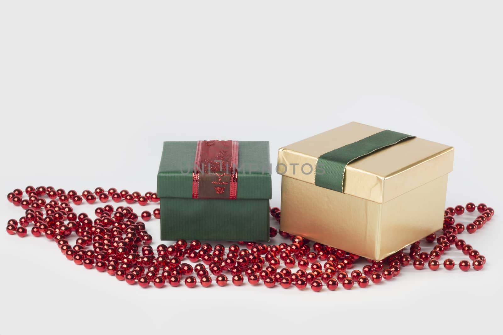 Two presents, green and gold, with ribbons, isolated on white background