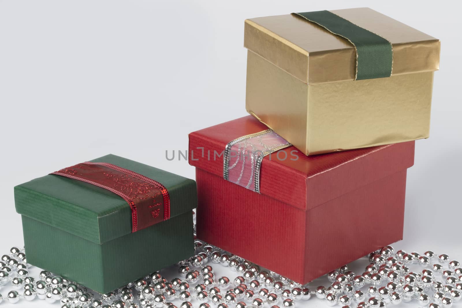 Three presesnts with ribbons, gold, green and red, isolated on white background