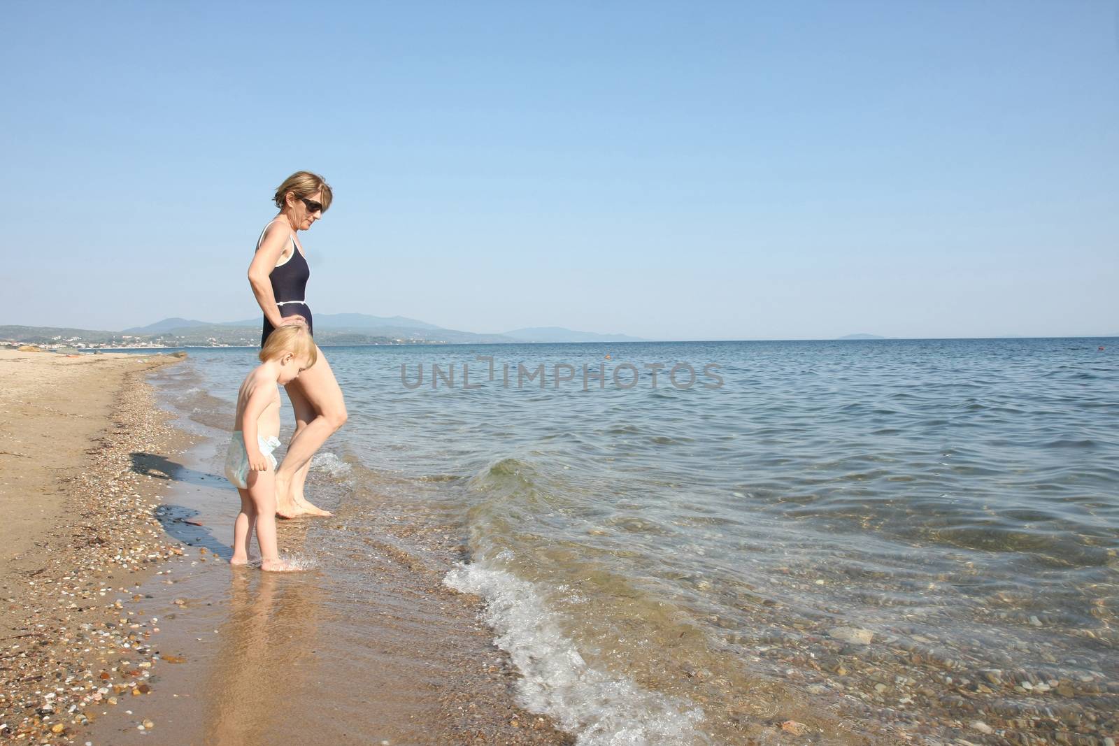 Grandmother and her granddaughter enjoying on the beach