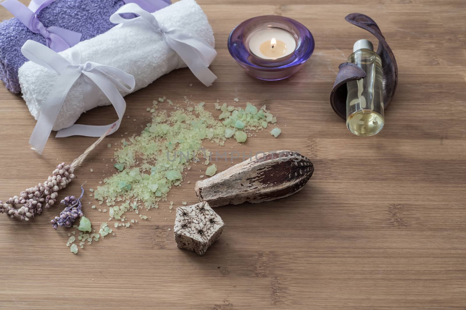 Spa concept. flowers,candles, aromatic salt,soap and bath purple and white towels on wooden background