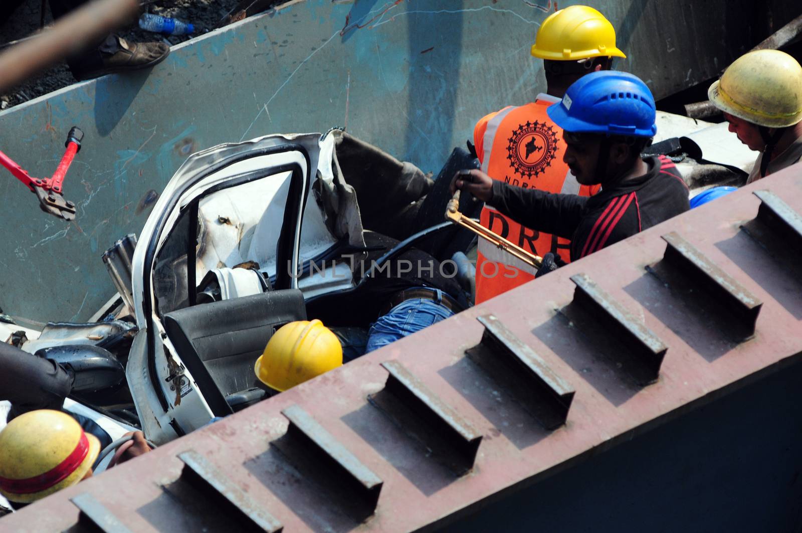 INDIA, Kolkata: Indian rescue workers and volunteers try to free people trapped under the wreckage of a collapsed flyover bridge in Kolkata on March 31, 2016. At least 14 people were killed and dozens more injured when a flyover collapsed in a busy Indian city on March 31, an official said, as emergency workers battled to rescue people trapped under the rubble.
