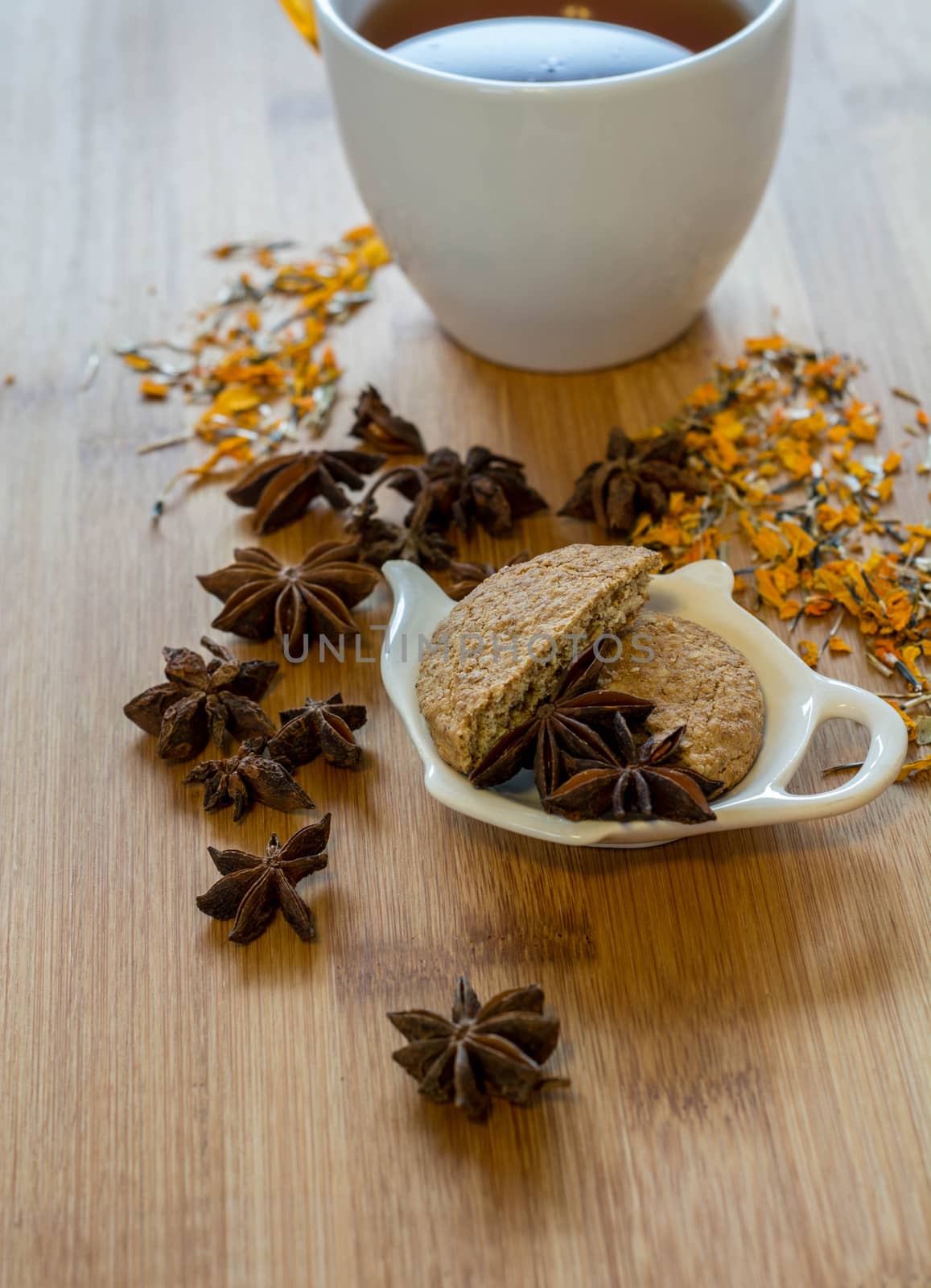 Tea, dried cinnamon, vegan cookies , and anise on wooden background