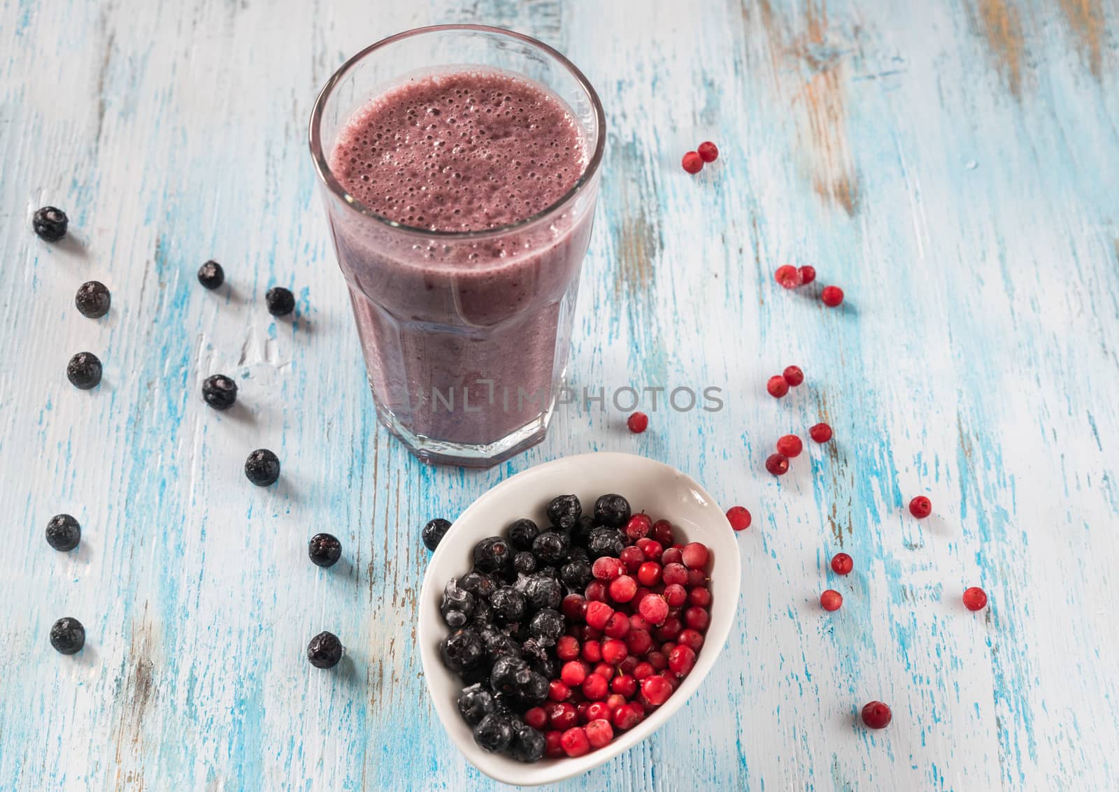 Berry smoothie with almond milk, cranberries,aronia and black currants in a glass on a dark background, top view