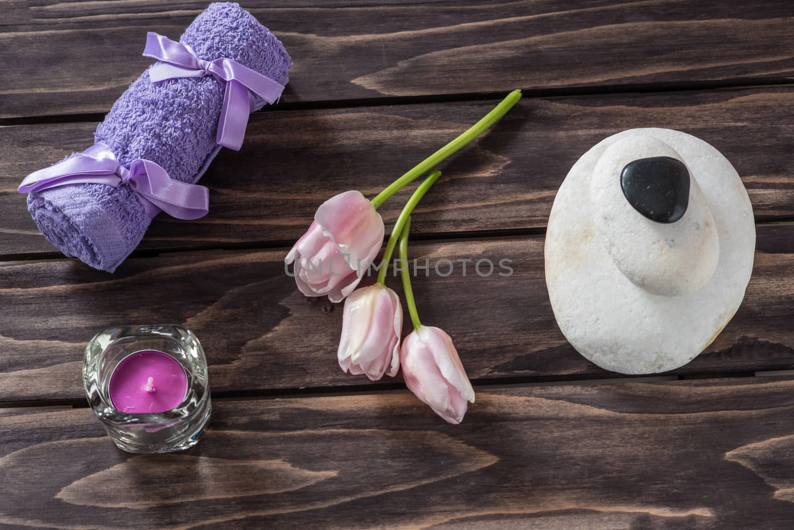 Spa concept. flowers,candles, aromatic salt,soap and bath purple towels on wooden background