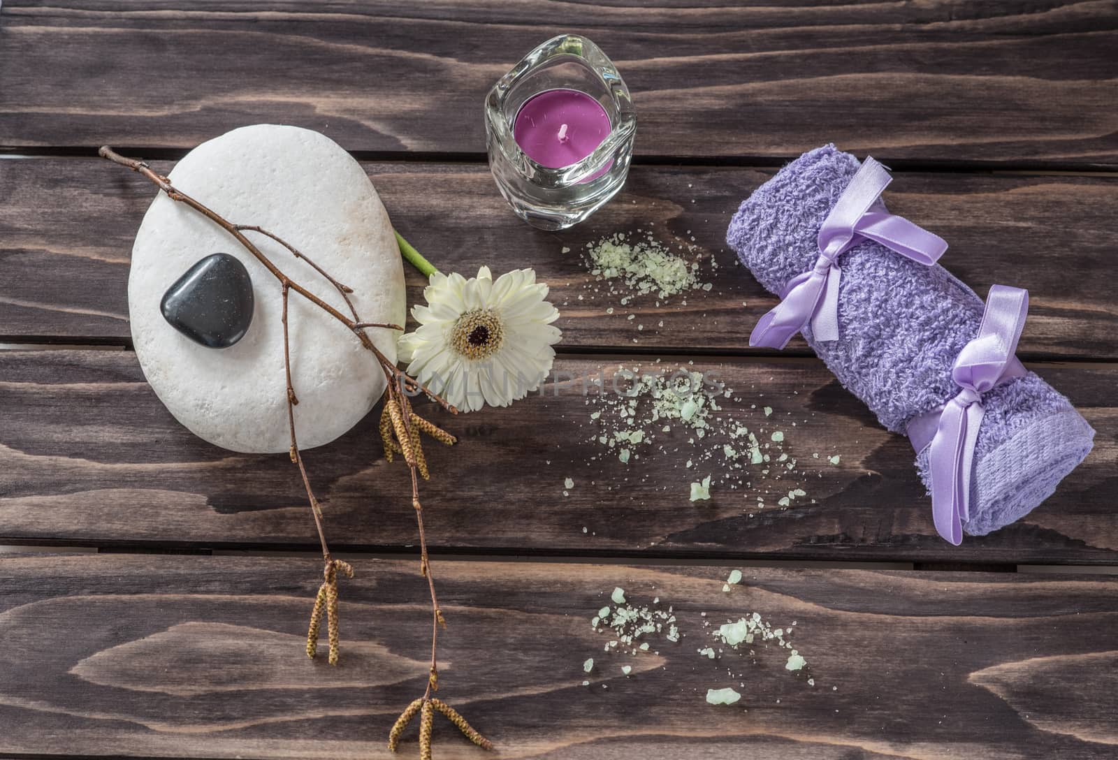 Spa concept. flowers,candles, aromatic salt and bath purple towel on wooden background
