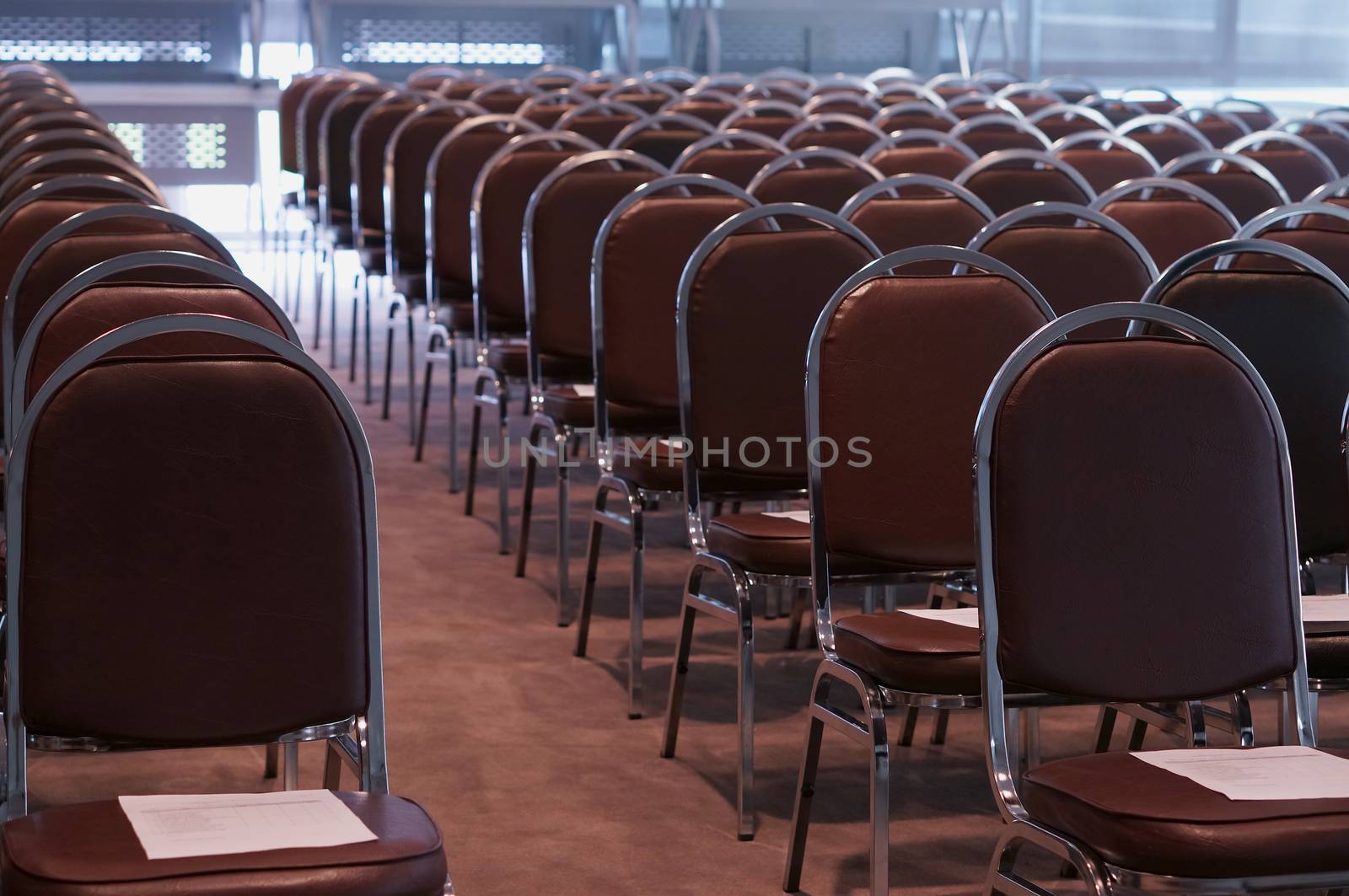 Many of brown chairs was placed in lobby for conference.
