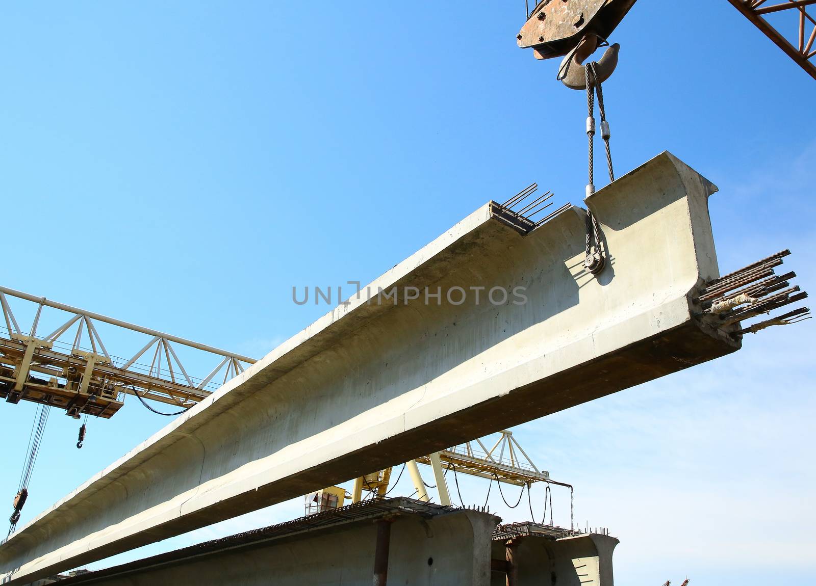 the concrete structure raise the crane on blue sky background by sergasx