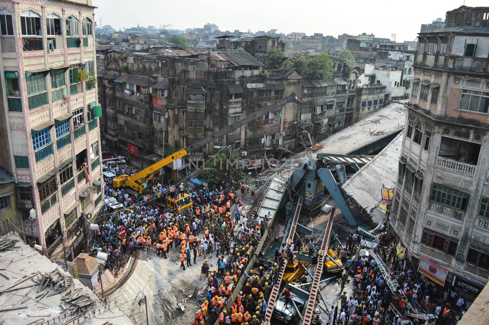 INDIA, Kolkata: Indian soldiers, rescue workers and volunteers try to free people trapped under the wreckage of a collapsed flyover bridge in Kolkata on March 31, 2016. At least 14 people were killed and dozens more injured when a flyover collapsed in a busy Indian city on March 31, an official said, as emergency workers battled to rescue people trapped under the rubble.