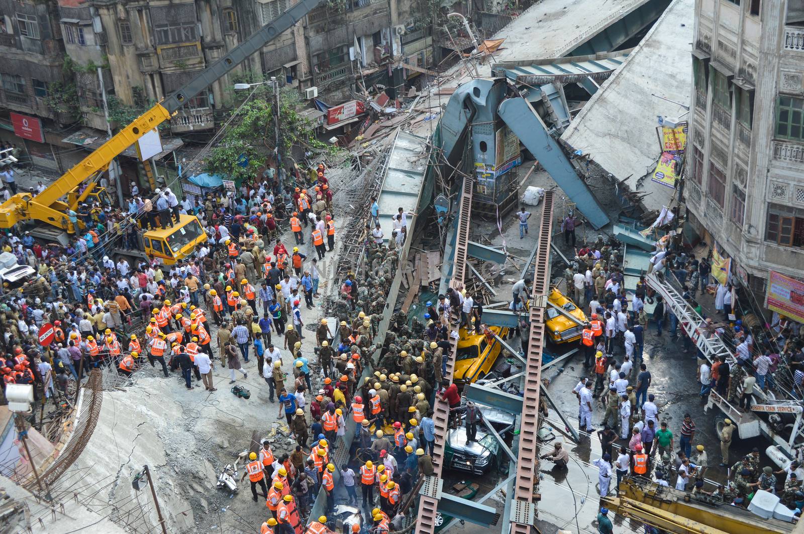 INDIA, Kolkata: Indian soldiers, rescue workers and volunteers try to free people trapped under the wreckage of a collapsed flyover bridge in Kolkata on March 31, 2016. At least 14 people were killed and dozens more injured when a flyover collapsed in a busy Indian city on March 31, an official said, as emergency workers battled to rescue people trapped under the rubble.