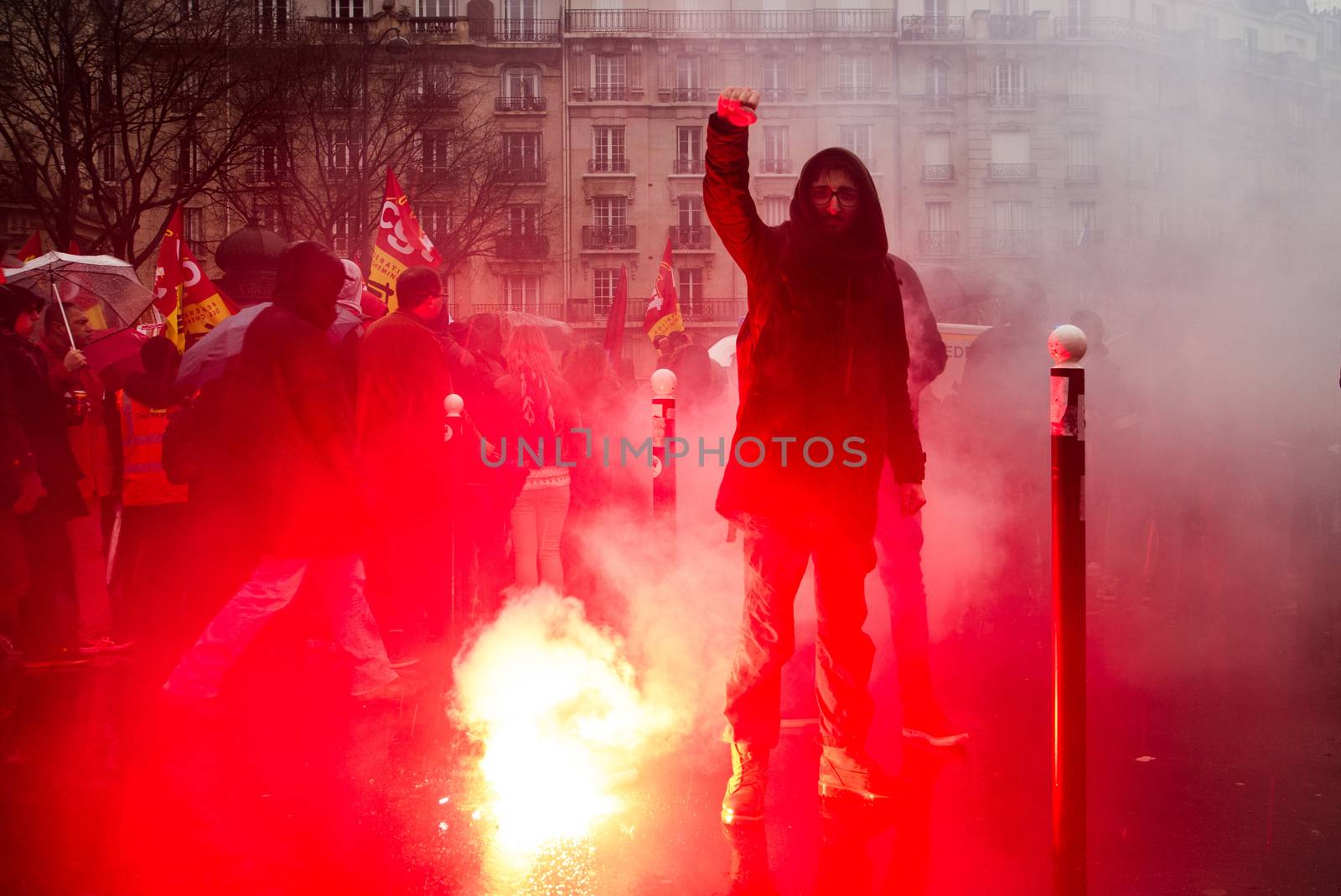 FRANCE, Paris: A protester raises his fist over a smoke bomb as thousands march against the French government's planned labor law reforms on March 31, 2016 in Paris. France faced fresh protests over labour reforms just a day after the beleaguered governme
