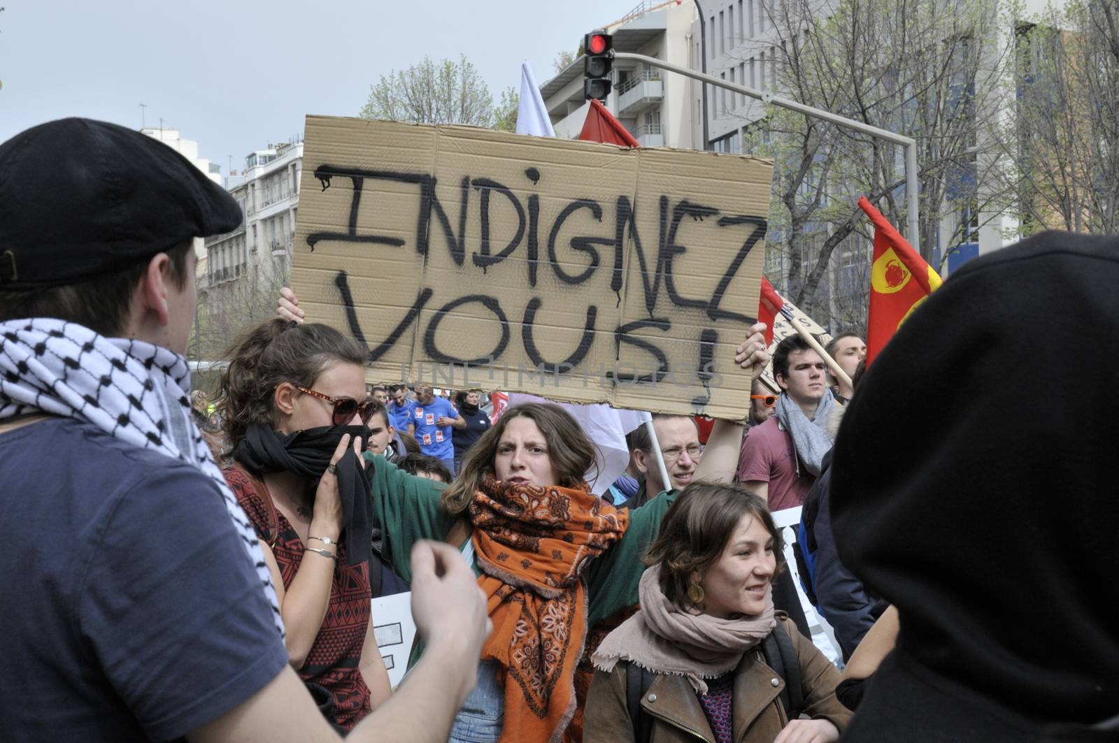 FRANCE, Marseille: A protester holds a sign reading 'be outraged' as thousands of protesters march during a demonstration against the French government's planned labour law reforms on March 31, 2016 in Marseille. France faced fresh protests over labour reforms just a day after the beleaguered government of President Francois Hollande was forced into an embarrassing U-turn over constitutional changes.