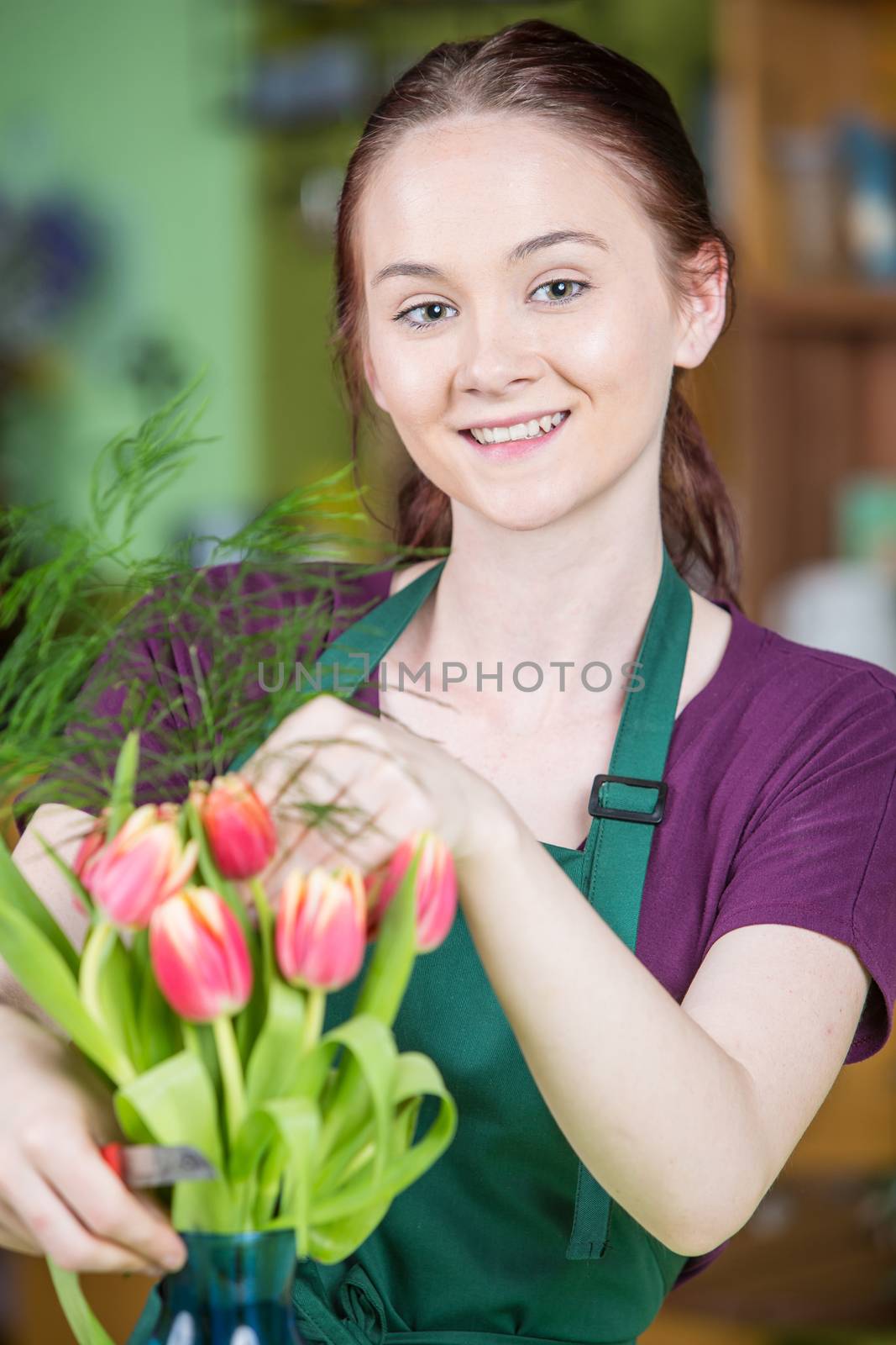 Smiling young woman creating a tulip arrangement