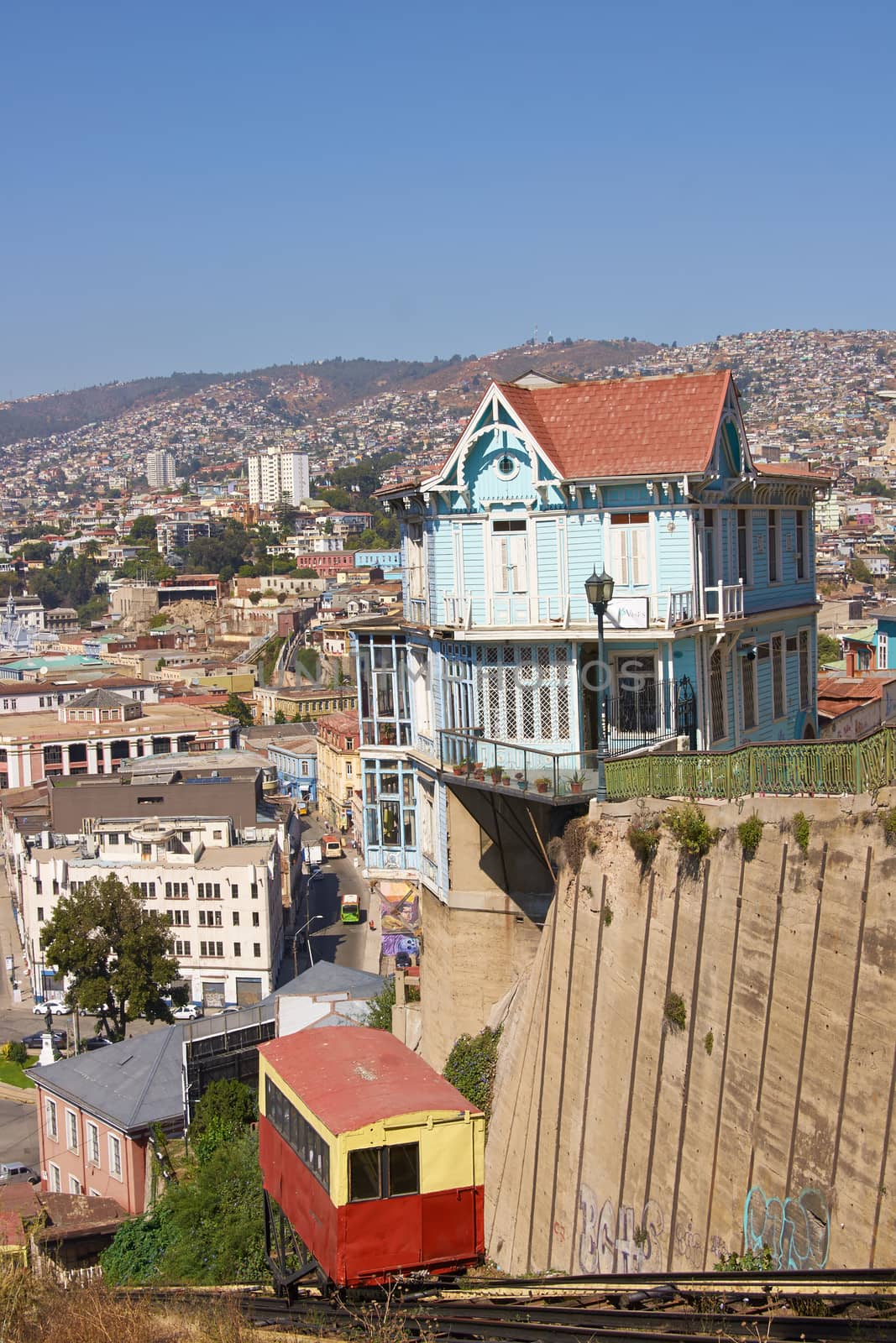 Carriage of the historic Ascensore Arttilleria travelling up a steep hillside in port city of Valparaiso in Chile .